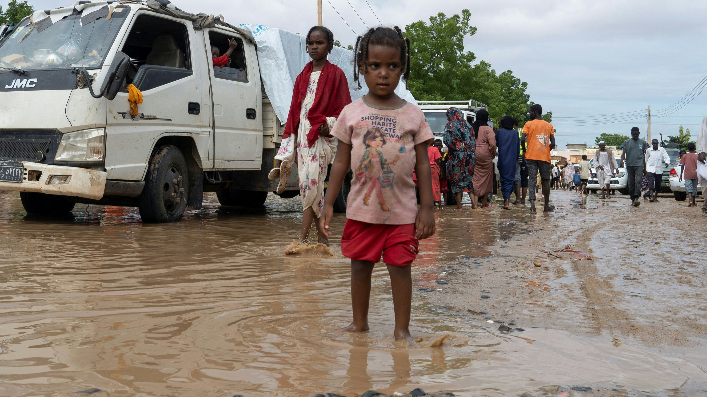 Displaced Sudanese people walk through a flooded street, following a heavy rainfall in Kassala, Sudan, July 26, 2024. REUTERS/Mohamed Abdulmajid