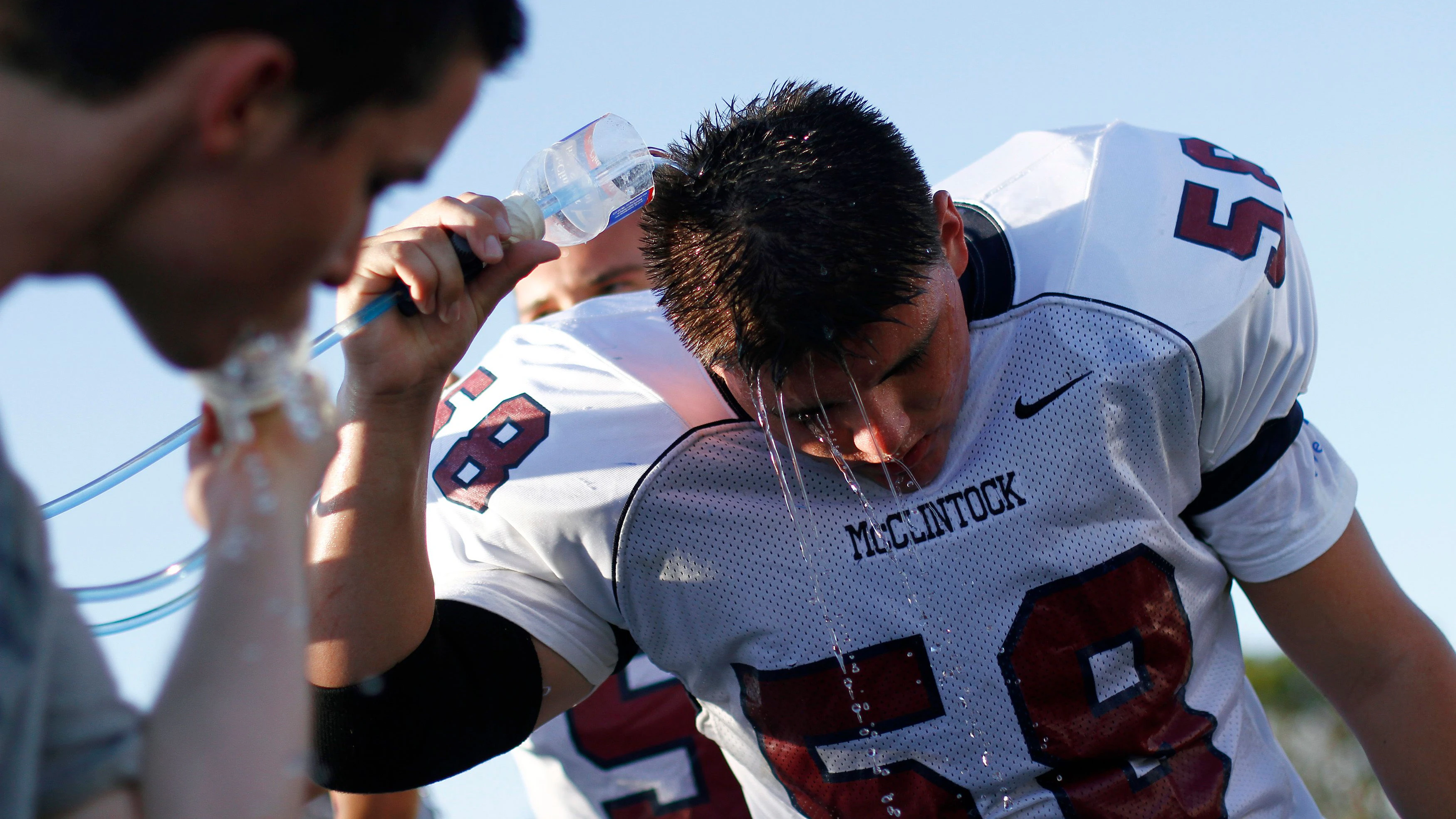 A McClintock High School Chargers football player cools down during a practice session in Tempe, Arizona August 4, 2011. In a summer that has seen record heat, severe droughts and four football-practice deaths, scientists and climatologists say the risks for players are higher than ever. REUTERS/Joshua Lott (UNITED STATES - Tags: ENVIRONMENT SPORT EDUCATION)