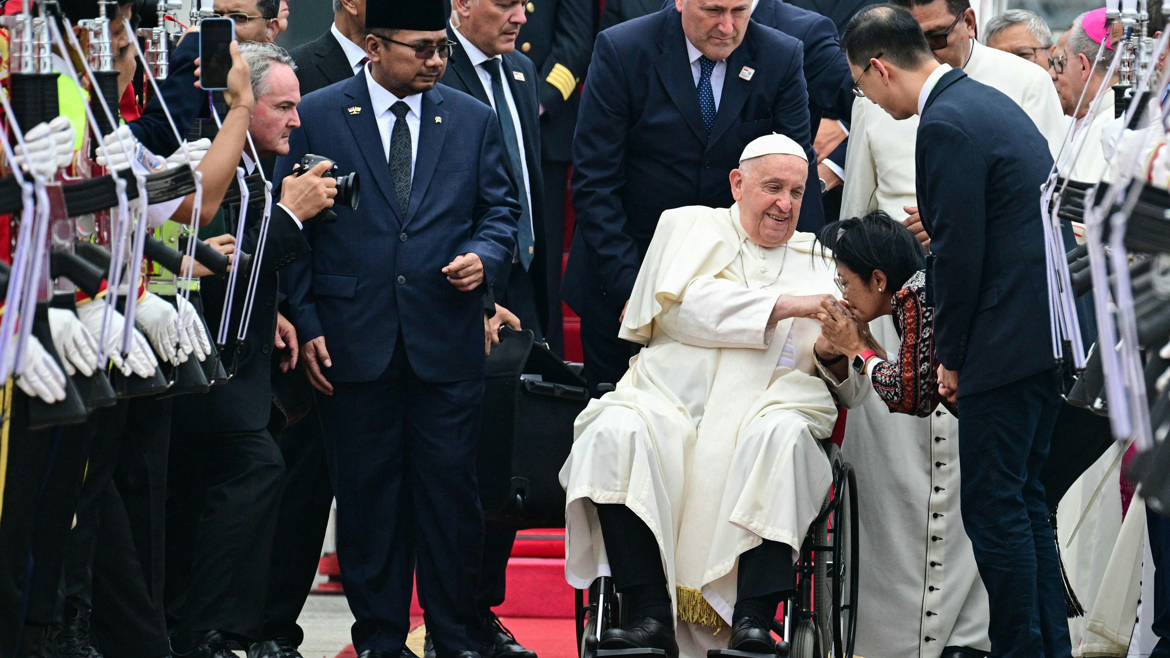 Download von www.picturedesk.com am 03.09.2024 (15:07).  Pope Francis (C, in wheelchair) is welcomed during his arrival at SoekarnoHatta International Airport in Jakarta on September 3, 2024. Pope Francis arrived in Muslim-majority Indonesia on September 3 for the first stop of a four-nation tour in the Asia-Pacific that will be the longest of the 87-year-old's papacy, according to an AFP reporter travelling with him. (Photo by Tiziana FABI / AFP) - 20240903_PD0639 - Rechteinfo: Rights Managed (RM) Nur fÃ¼r redaktionelle Nutzung! Werbliche Nutzung erfordert Freigabe: bitte schicken Sie uns eine Anfrage.