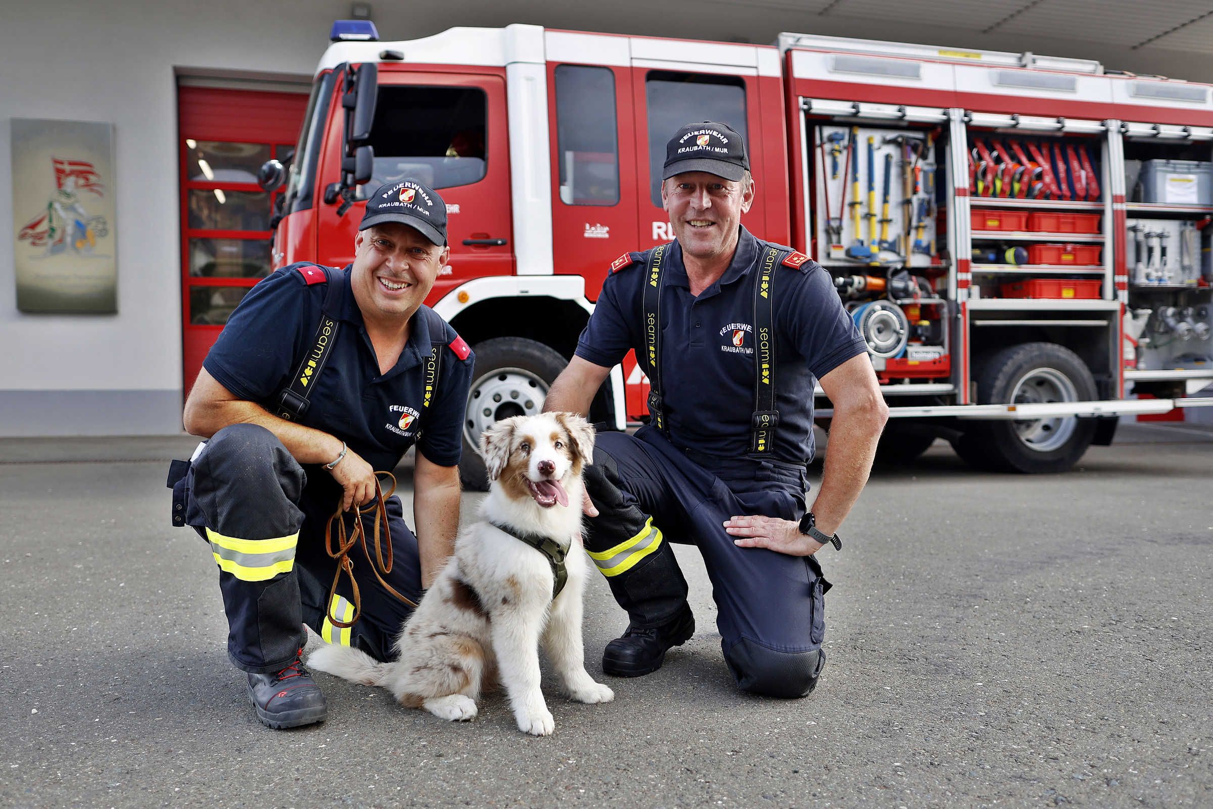 Welpe Marie mit Herrchen Thomas Bischof und Feuerwehrkommandant Robert Gmundner (v.l.).