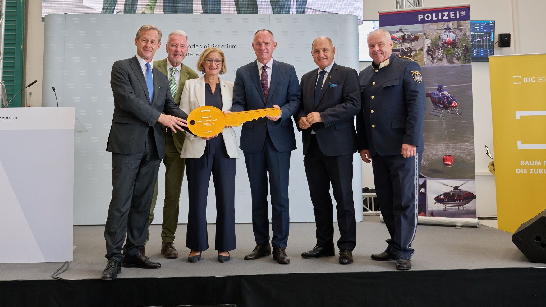 Gerald Beck, Geschäftsführer der Bundesimmobiliengesellschaft, Bürgermeister Klaus Schneeberger, Landeshauptfrau Johanna Mikl-Leitner, Minister Gerhard Karner, Nationalratspräsident Wolfgang Sobotka und Bernhard Treibenreif, Leiter der Direktion Spezialeinheiten beim Einsatzkommando Cobra, bei der symbolischen Schlüsselübergabe für den neuen Stützpunkt der Flugpolizei.