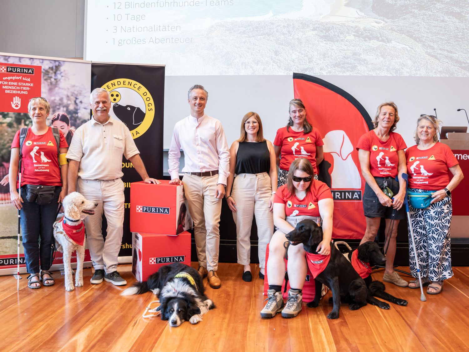 Tierisch-menschliches Team: Sonja mit ihrem Hund Emil, Karl Weissenbacher, Purina Österreich-Geschäftsbereichleiter Marius Baumeister, Katharina Krenn von Purina, IDA-Vorsitzende Ingrid Sweeney, Laura mit ihrem Hund Zuri, Maria mit ihrem Hund Hero und Maria Gerstmann von Purina werden das Abenteuer wagen.