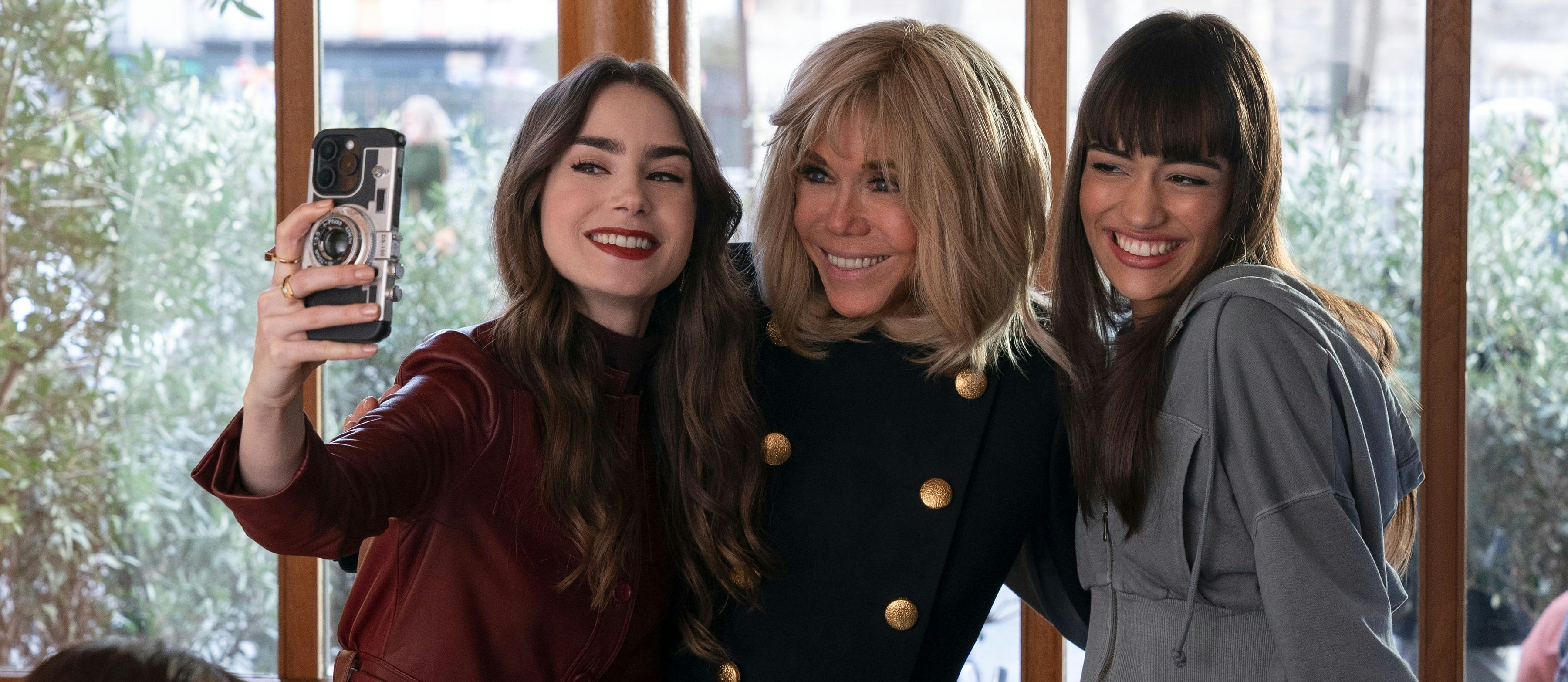 Präsidiales Selfie: Emily (Lily Collins) posiert in Episode 7 der 4. Staffel mit Brigitte Macron, der Ehefrau von Staatspräsident Emmanuel Macron, und ihrer neuen Kollegin Genevieve (Thalia Besson, Tochter von Regie-Legende Luc Besson). Brigitte Macron trug dabei ihre eigene Garderobe, wurde in Frankreich berichtet