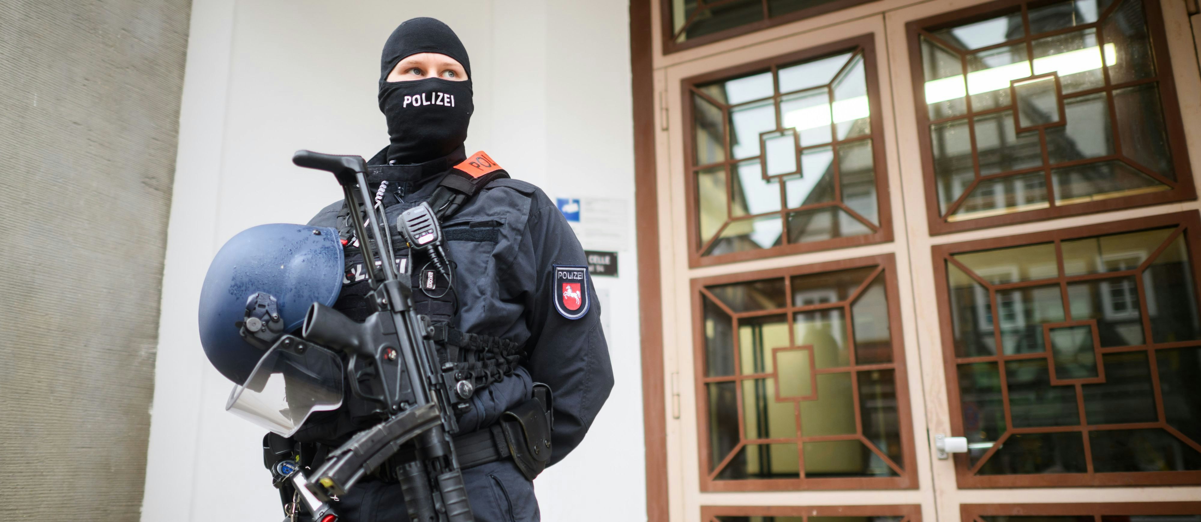 Ein schwer bewaffneter Polizist bewacht ein Gerichtsgebäude in Celle, Deutschland