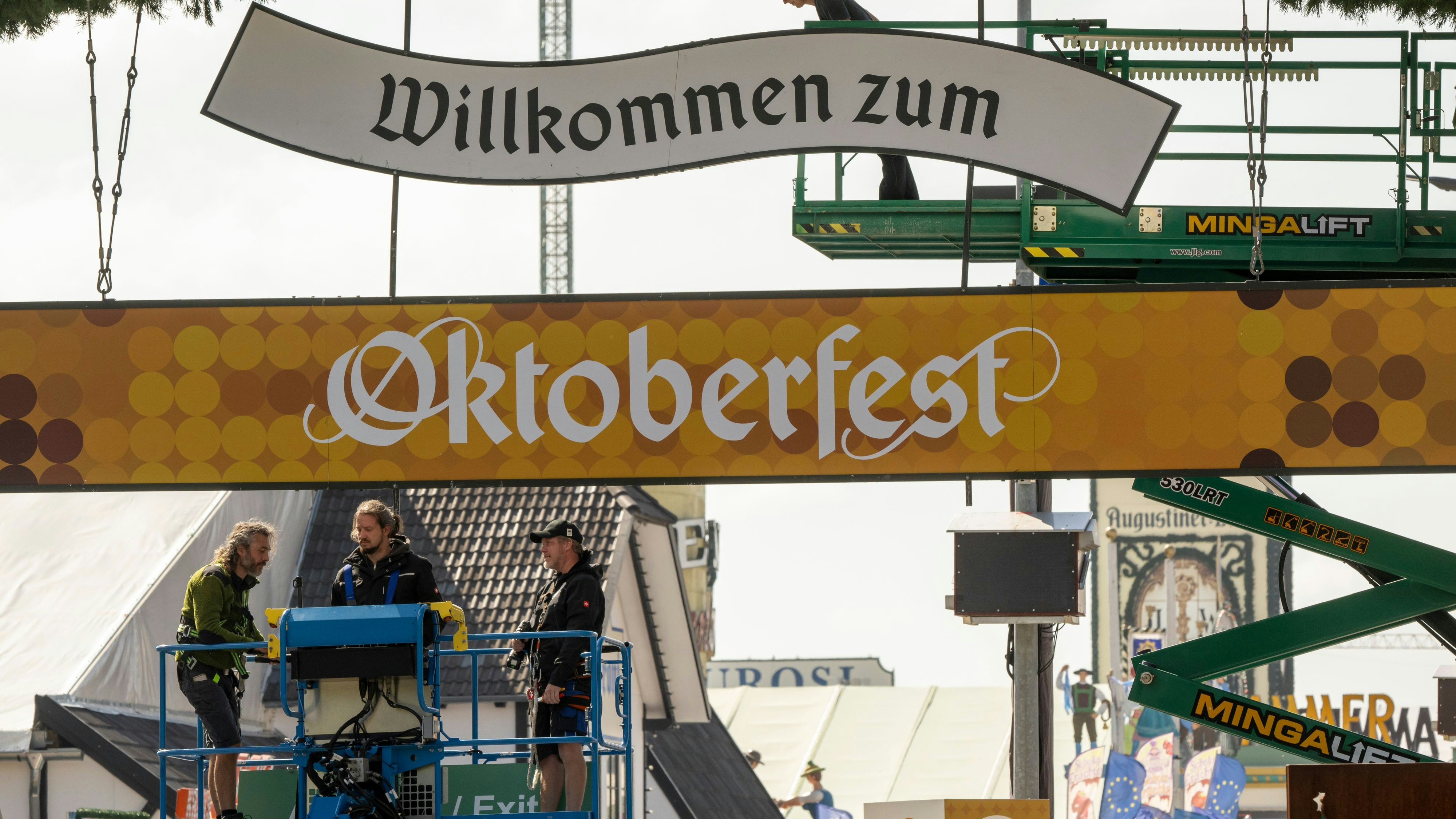 Download von www.picturedesk.com am 18.09.2024 (14:42).  18 September 2024, Bavaria, Munich: Workers put up signs at the main entrance to the Oktoberfest grounds. On September 18, 2024, the police and the district administration department held a press conference on security at the Oktoberfest and informed about the security and traffic measures. The 189th Oktoberfest will take place on Munich's Theresienwiese from September 21 to October 6, 2024. Photo: Peter Kneffel/dpa - 20240918_PD3905 - Rechteinfo: Rights Managed (RM)