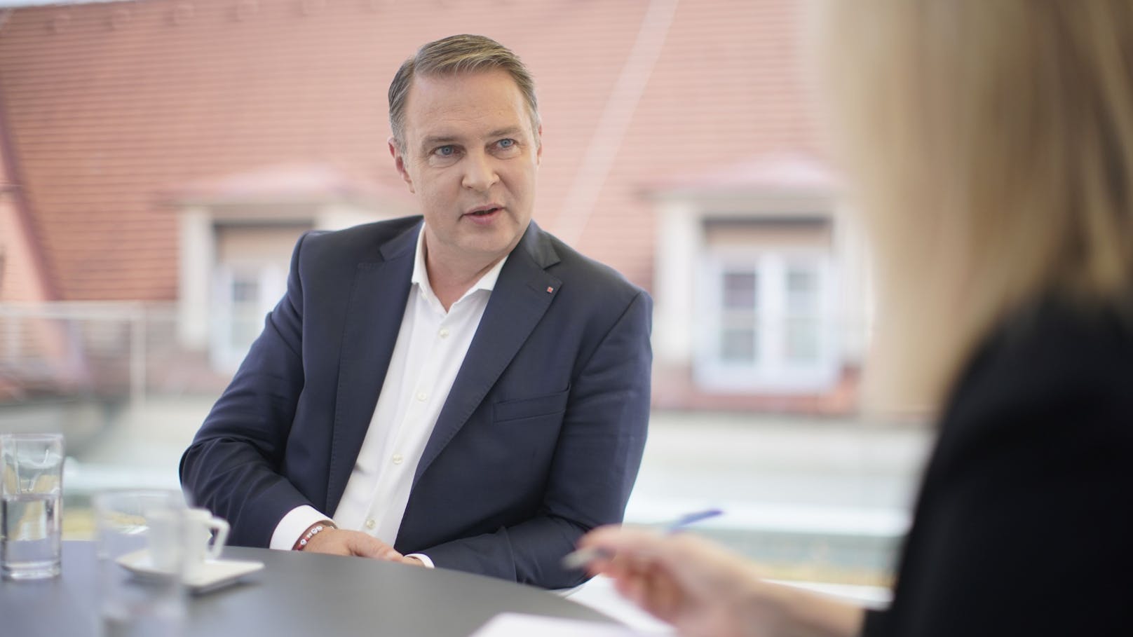 SPÖ-Chef Andreas Babler beim Interview mit <em>"Heute"</em>-Redakteurin Angela Sellner auf der Dachterrasse des Rathauses Traiskirchen.