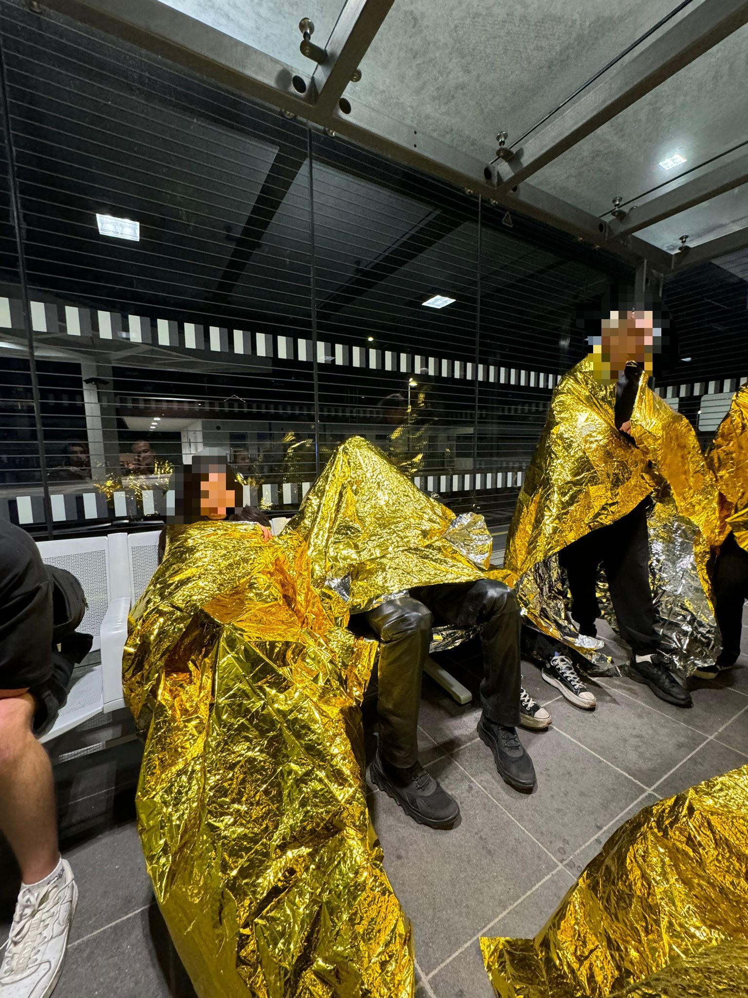 Besucher wärmen sich mit Rettungsdecken nach Abbruch des Events!