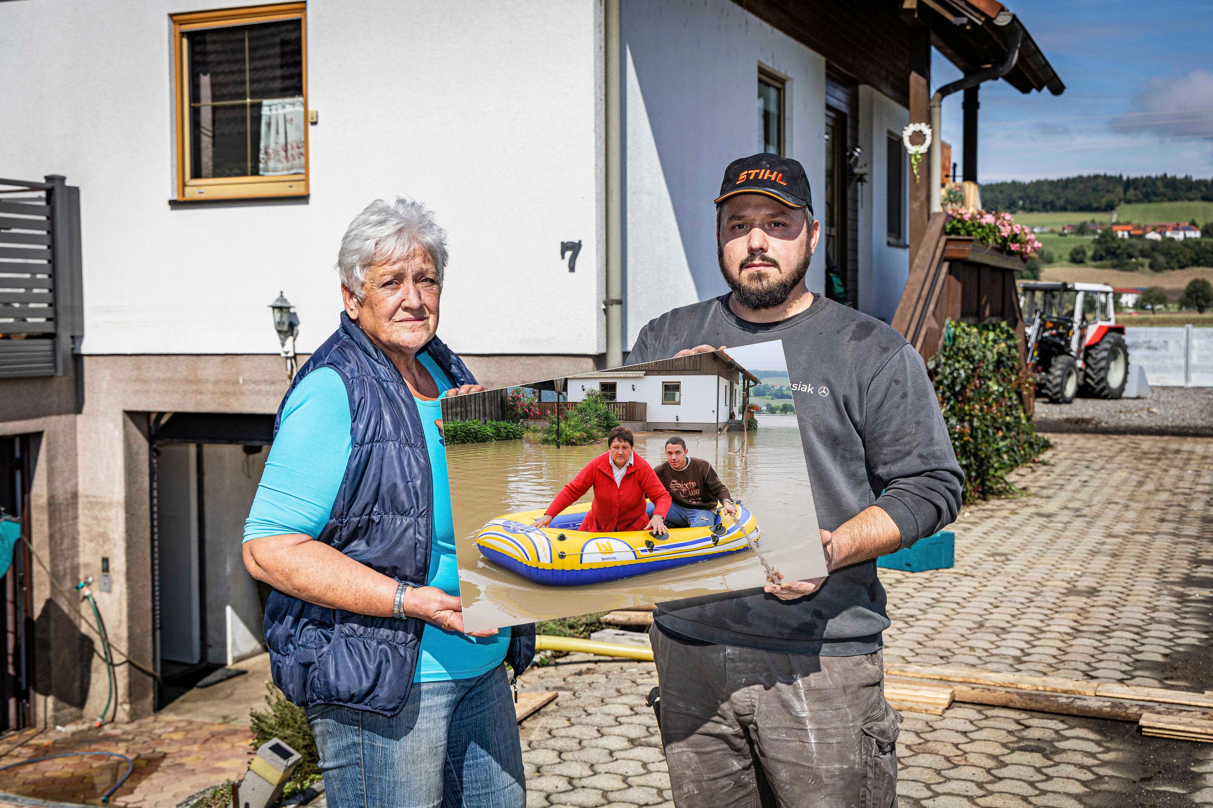 Herta Graf (64) und Sohn Stefan (34) heute und 2009 im Schlauchboot vor dem Haus.