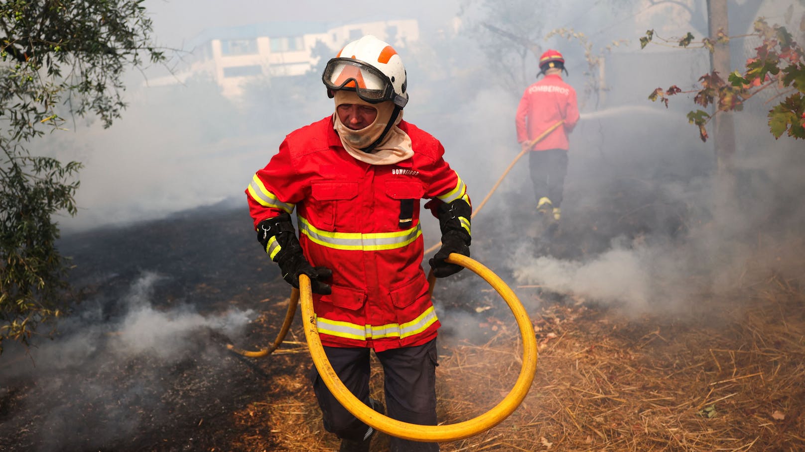 Feuerwehrleute löschen einen Flächenbrand in Penalva do Castelo, Portugal,