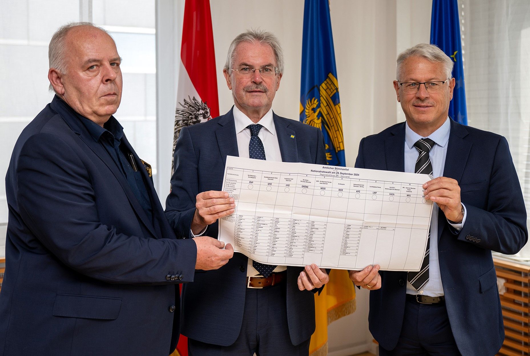 Landtagspräsident Karl Wilfing (M.), Peter Anerinhof (r.), Leiter der Abteilung Wahlen und Joachim Weninger von der Abteilung Wahlen mit einem Stimmzettel.