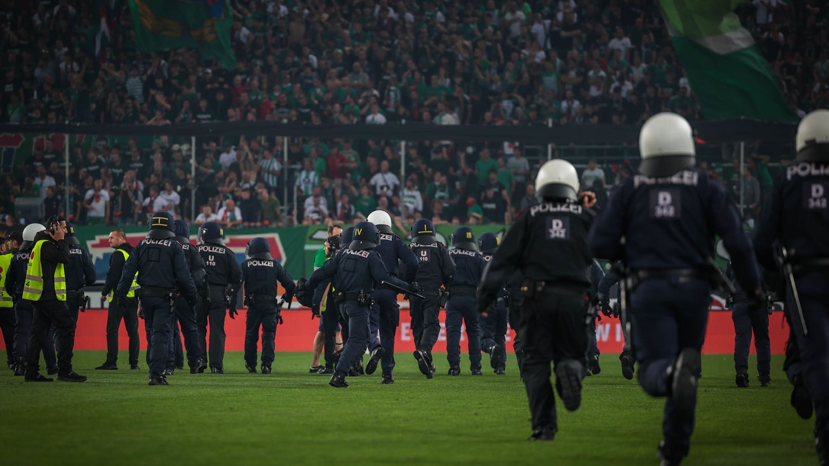 Mittlerweile bildete sich ein Polizeiteam, das den Gästesektor komplett umzingelte.