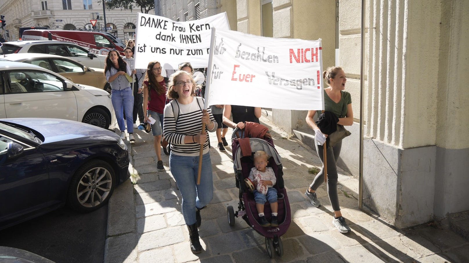 Die Betroffenen der AMS Rückzahlungen machen ihre Forderungen auf Bannern deutlich