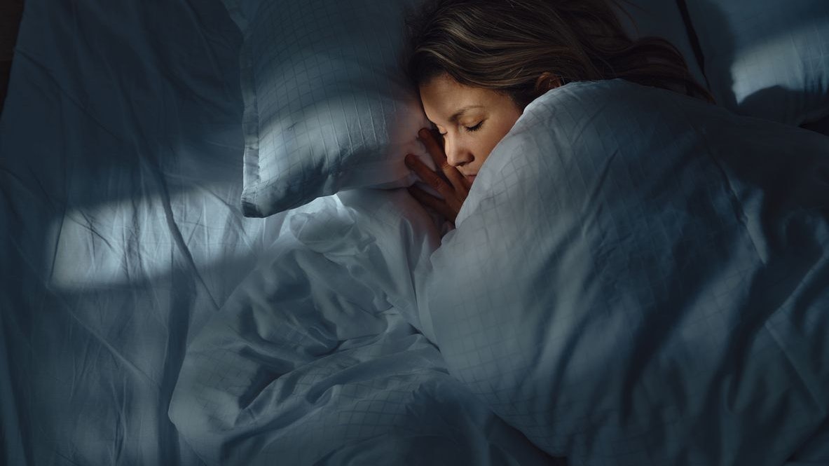High angle view of a woman taking a nap in her bed at night. Photographed in medium format.