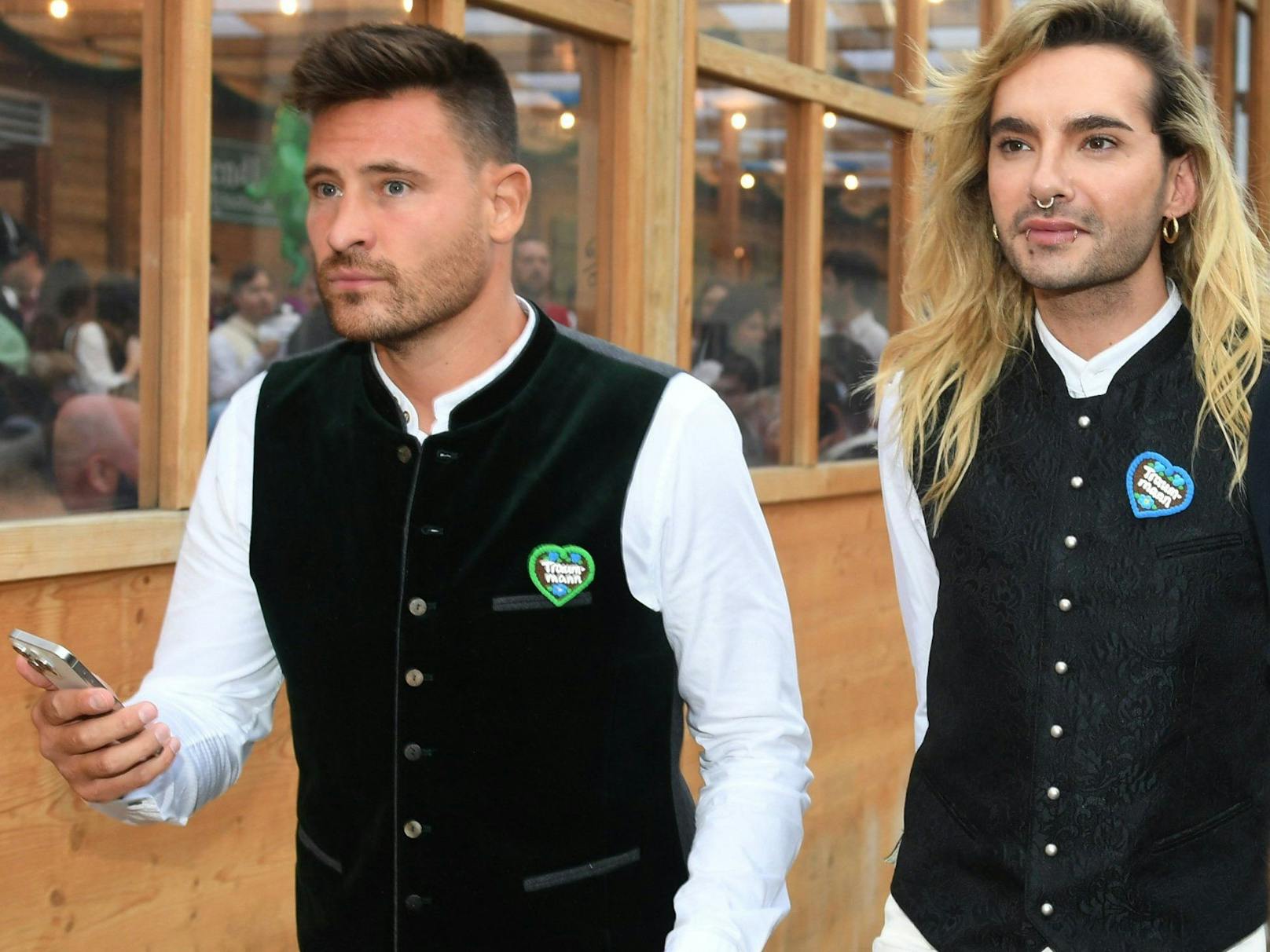 Bill Kaulitz und Marc Eggers beim gemeinsamen Auftritt auf dem Oktoberfest am 26. September. Beide tragen einen Anstecker in Form eines Lebkuchenherzens mit der Aufschrift "Traummann".