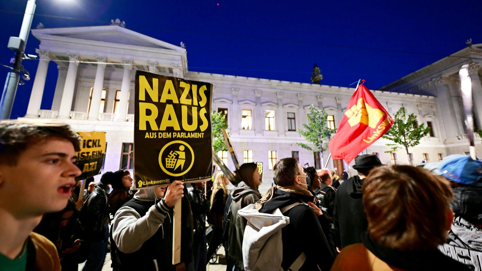 Vor dem Parlament in Wien gehen Demonstranten auf die Straße. 