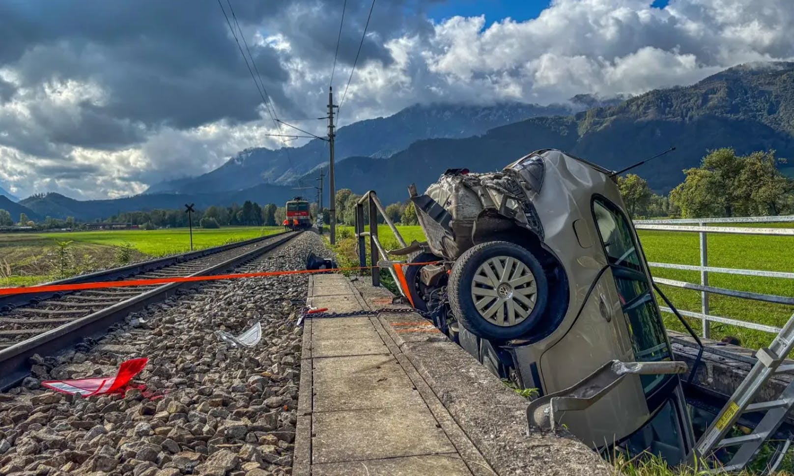 Zug schleudert Auto weg, Lenker in Wrack eingeklemmt