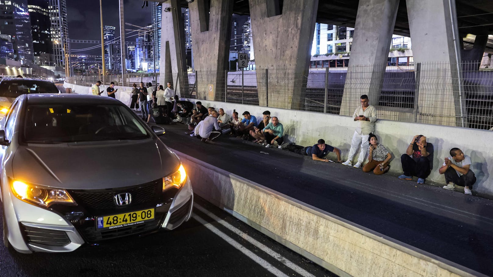 Bewohner von Tel Aviv suchen Schutz unter einer Autobrücke. Im ganzen Land herrscht Raketenalarm.