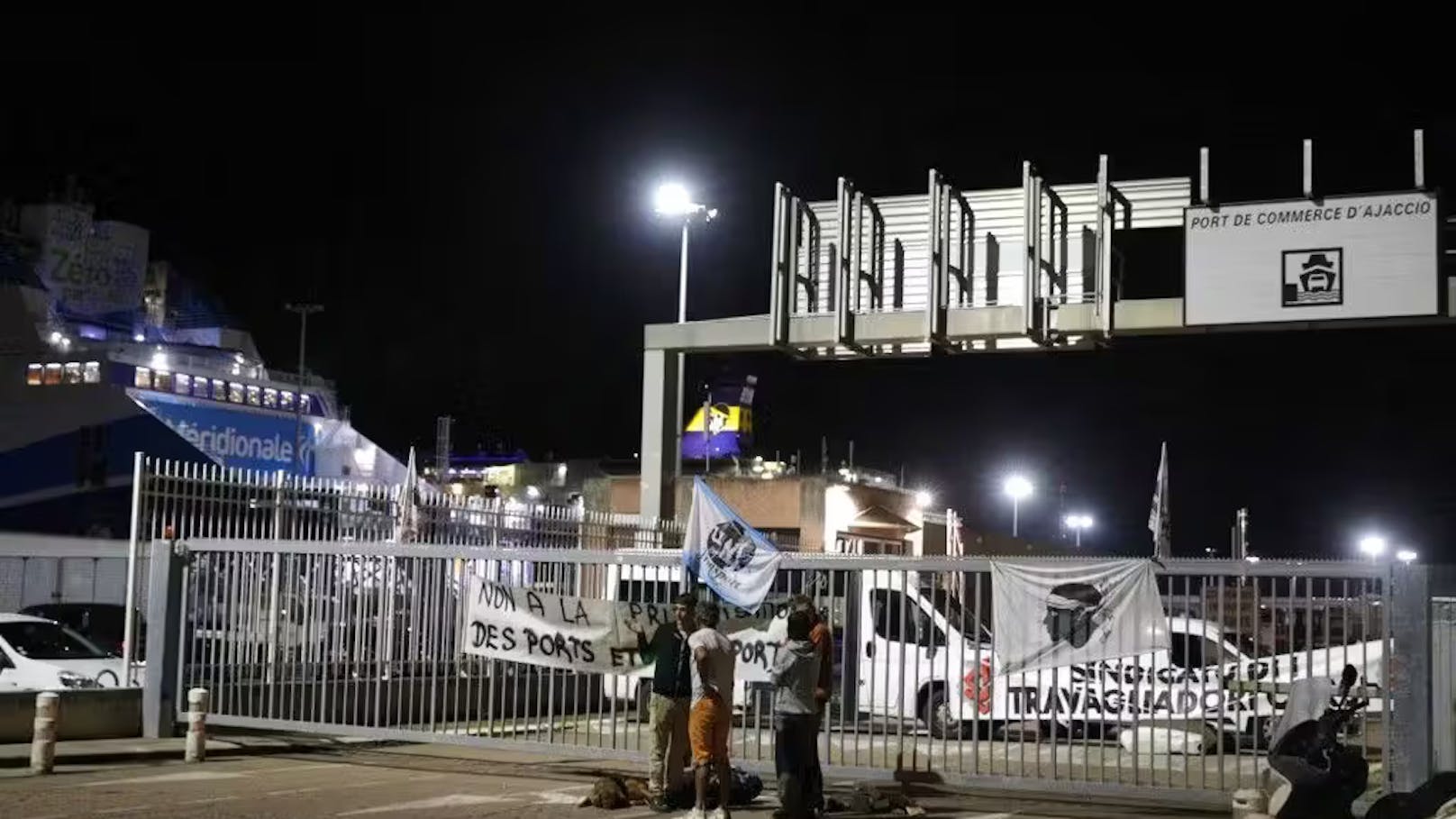 Keine Privatisierung der Häfen und Flughäfen steht auf einem Banner vor einem verschlossenem Hafen.