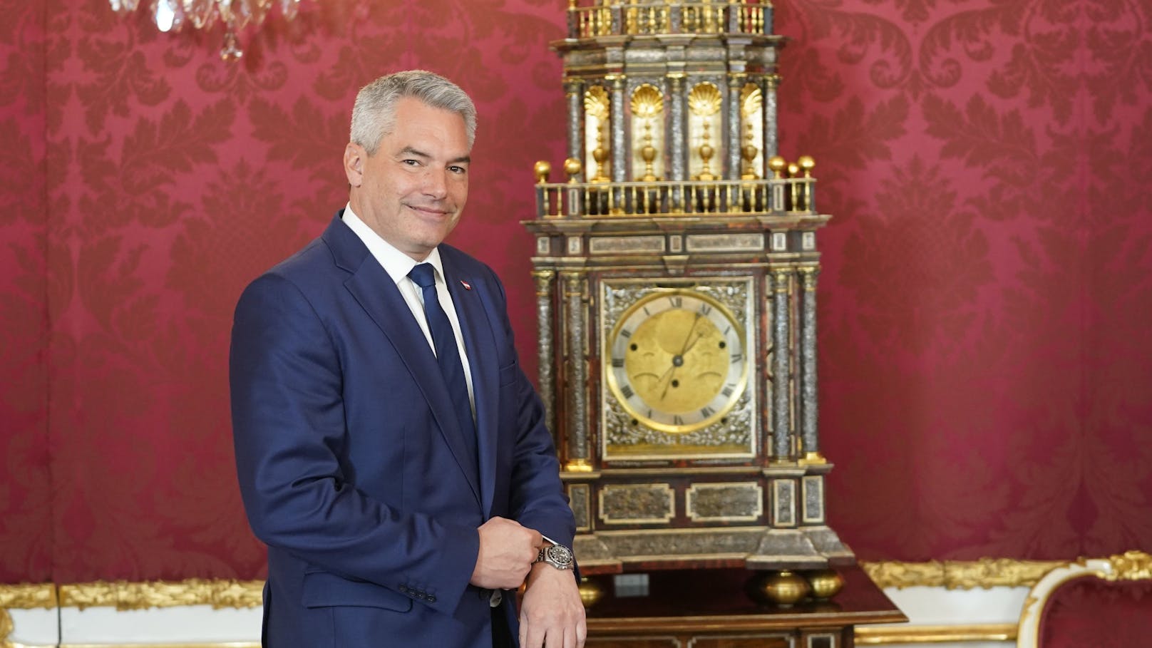 Uhrenvergleich: Karl Nehammer überprüft die Zeitangabe seiner Armbanduhr (eine Seyko Kinetic) mit der berühmten Standuhr im Maria-Theresien-Zimmer in der Hofburg.