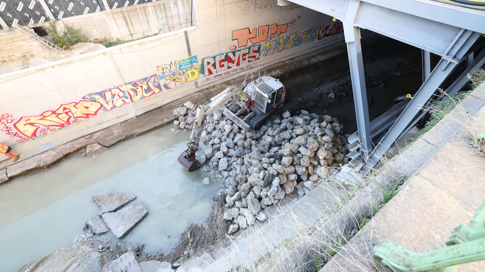 Mit Steinen werden Blockaden im Wienfluss gebaut