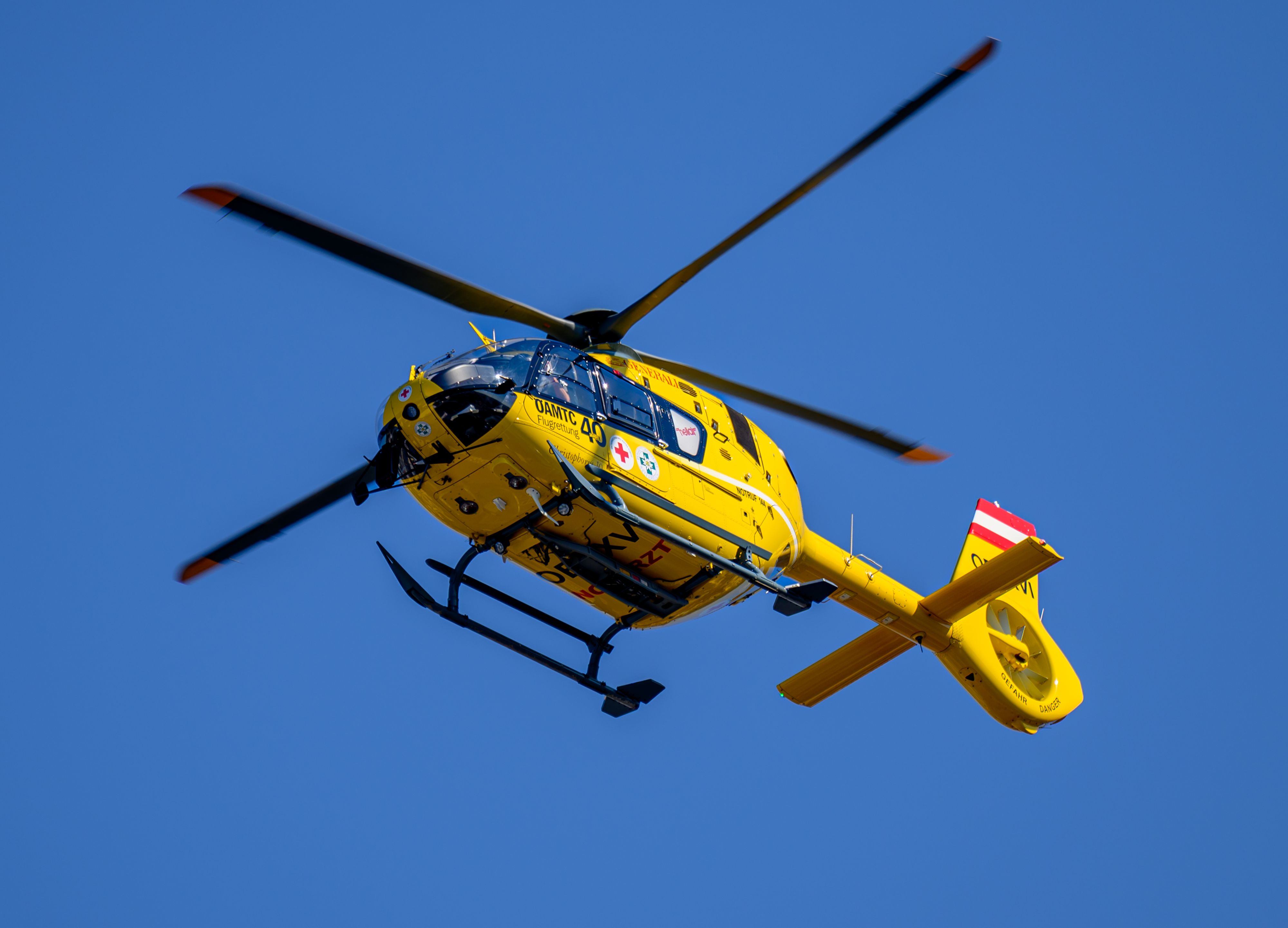 Ein gelber Rettungshubschrauber des ÖAMTC mit der Kennung 