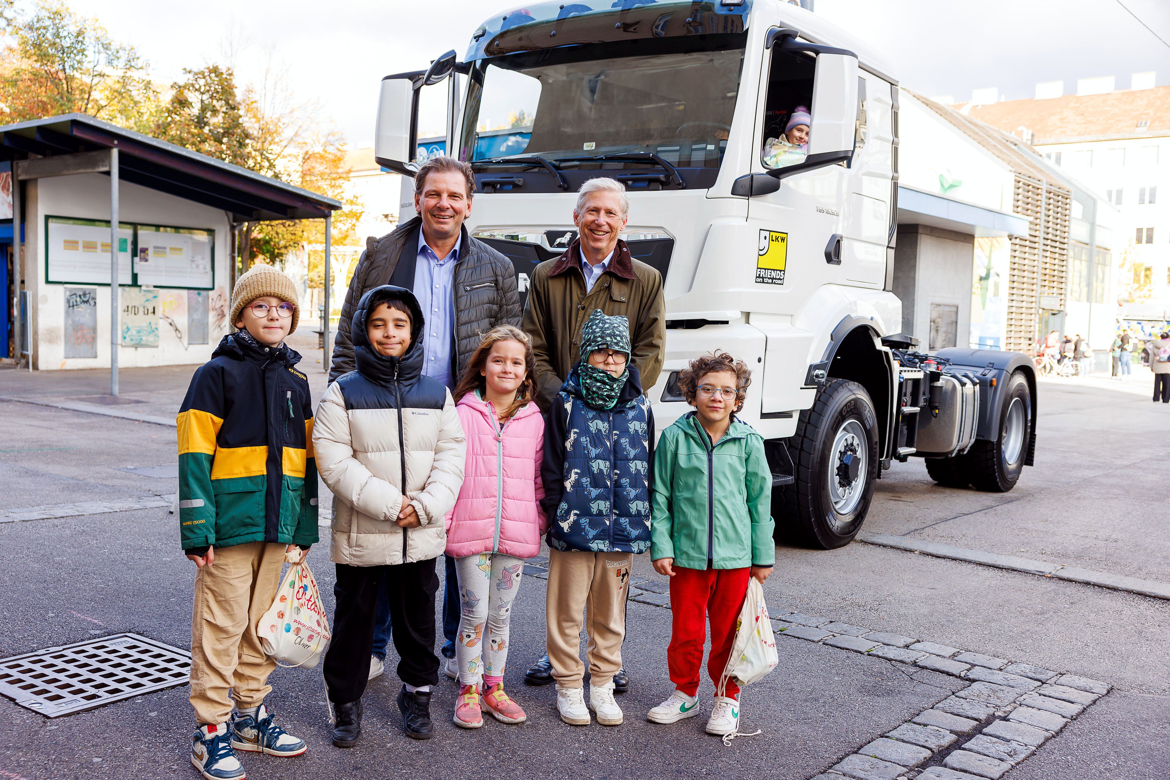 Wolfgang Böhm, Obmann der Wiener Transporteure, und Ludwig Richard, Obmann der Wiener Autobusunternehmen in der Wirtschaftskammer Wien, mit Volksschulkindern beim Toter-Winkel-Workshop. Kinder lernten auch am Steuer des Lkw die Gefahren einzuschätzen.