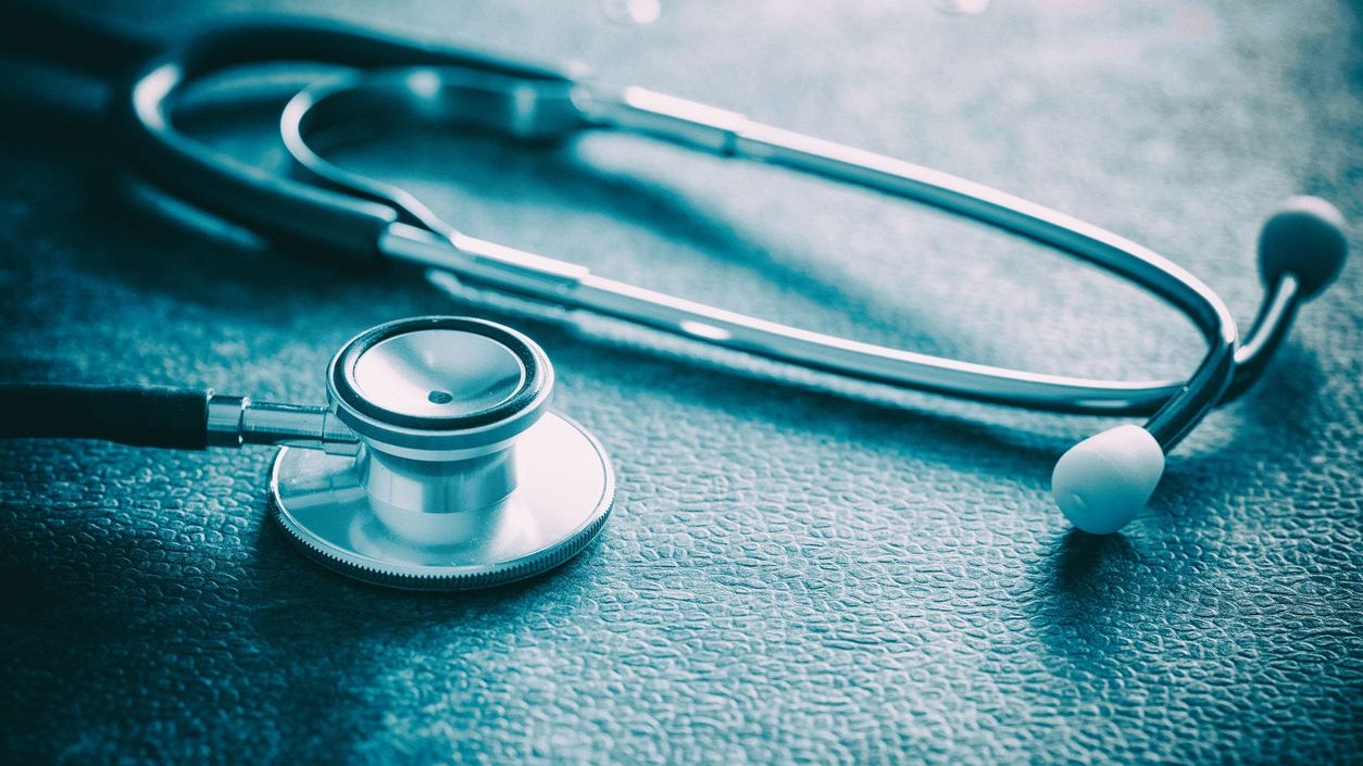 Stethoscope lying on dark blue background closeup