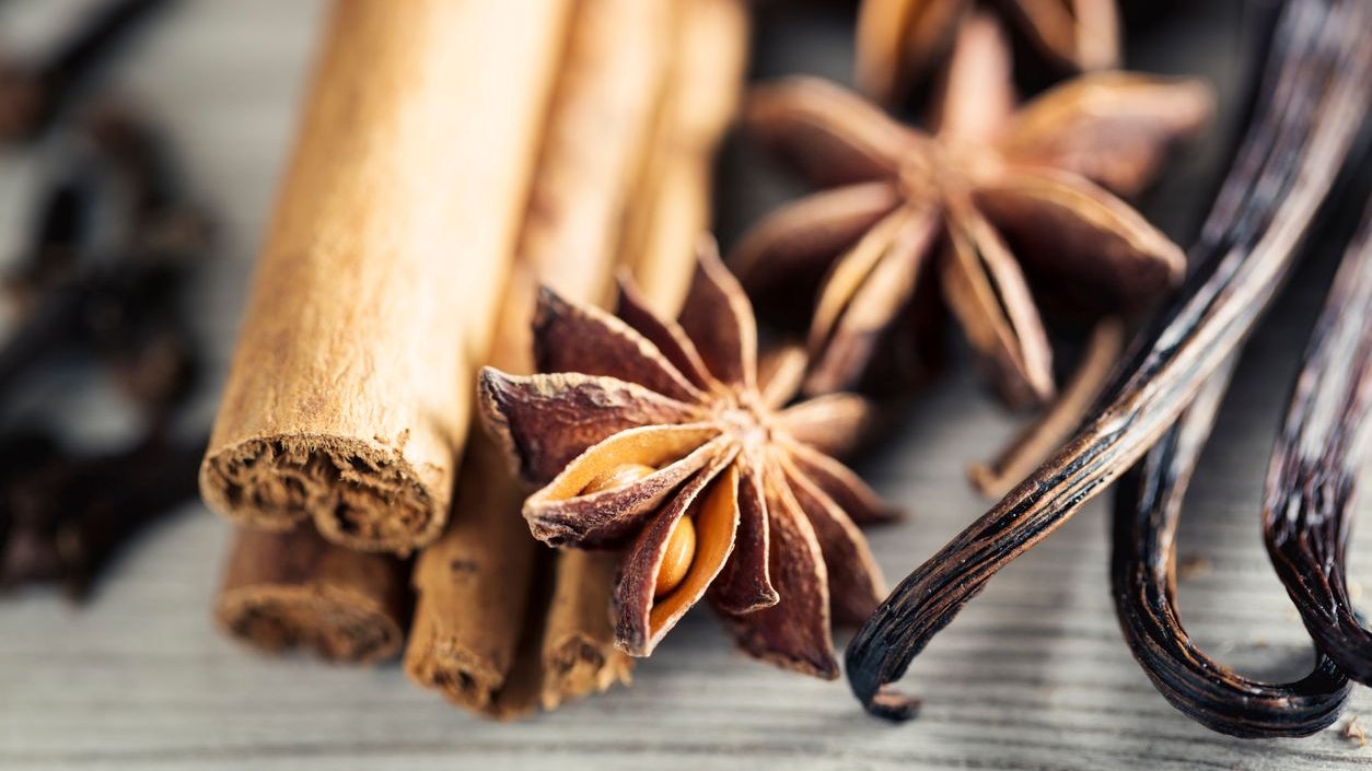 spices like anise,, cinnamon, vanilla, clove, green cardamon, used for christmas baking, on wooden background