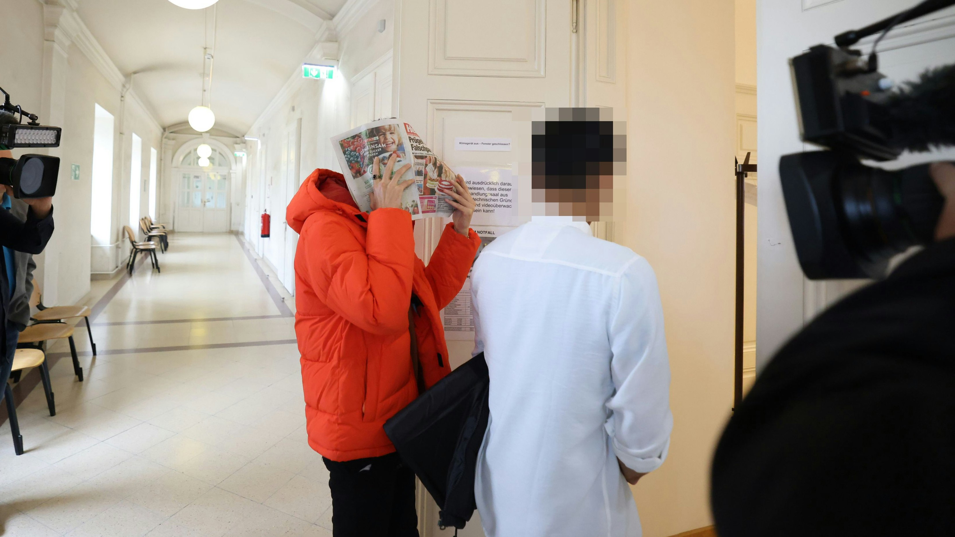 Der Angeklagte (in der orangenen Jacke) vor Gericht; neben ihm ein Zeuge, der die 14-Jährige ebenfalls getroffen hatte.