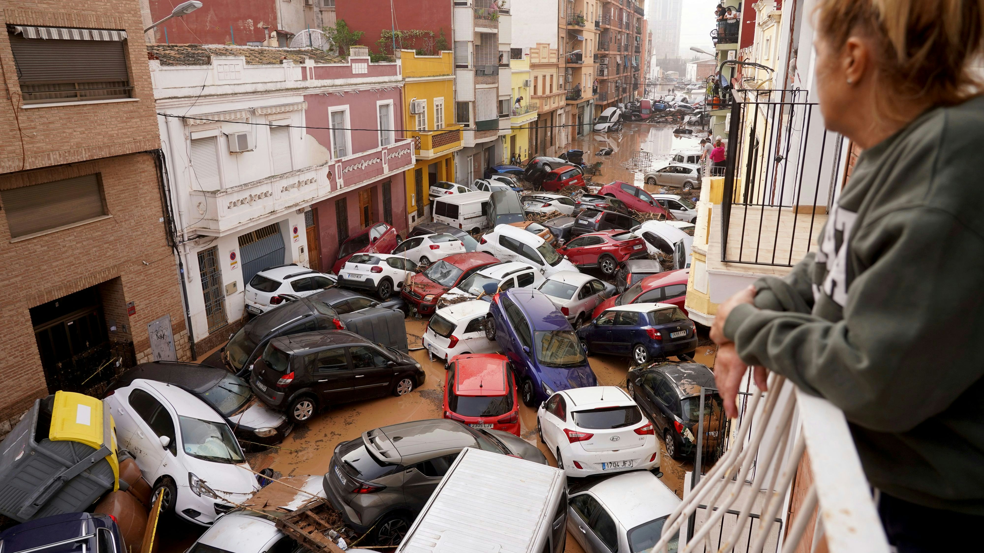 Das Wasser geht weg: Eine Frau blickt in Valencia auf eine Straße, in die es Autos gespült hat