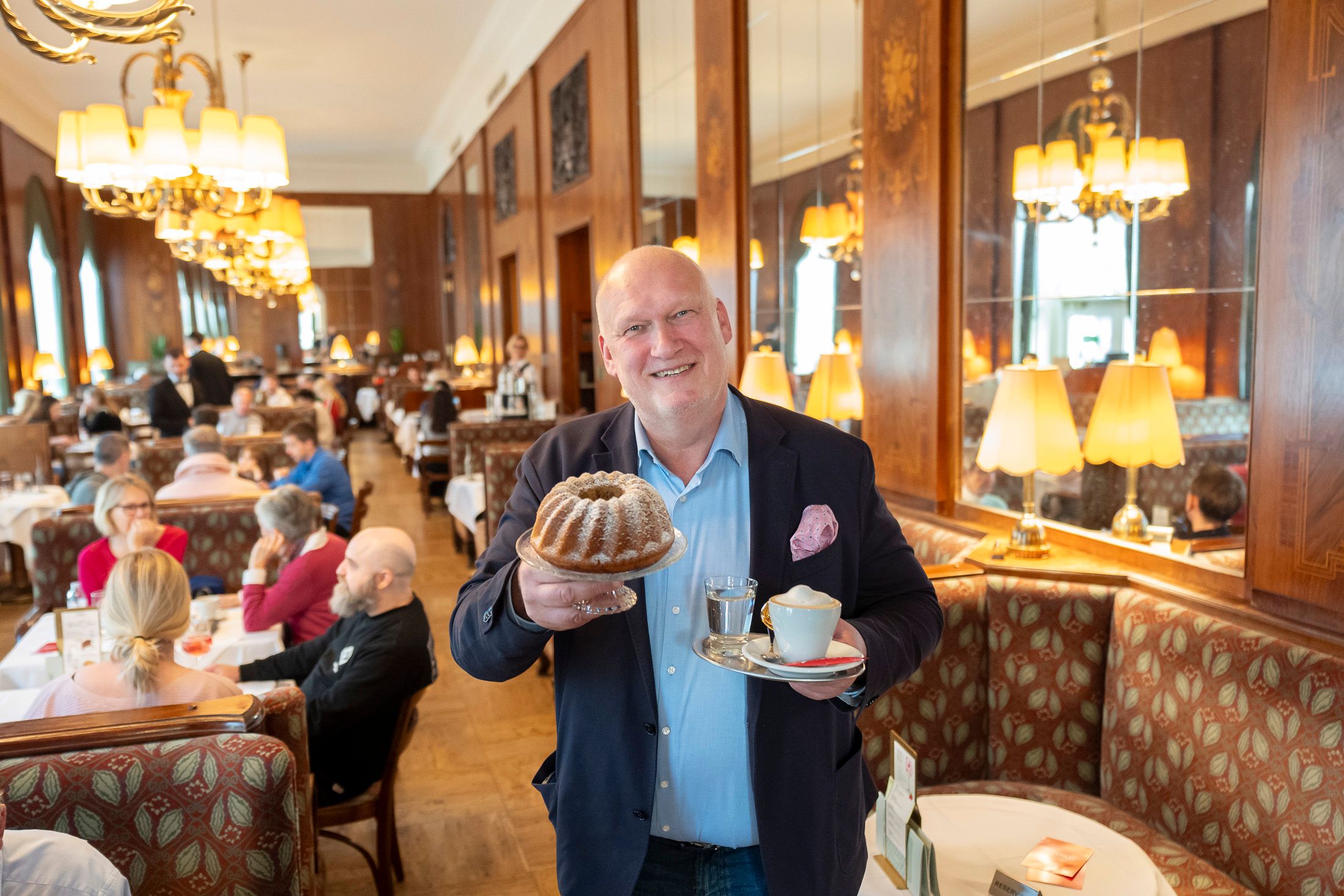 Geschäftsführer des Café Landtmann, Berndt Querfeld, mit Kaffee und Kuchen – zubereitet ohne tierische Lebensmittel.