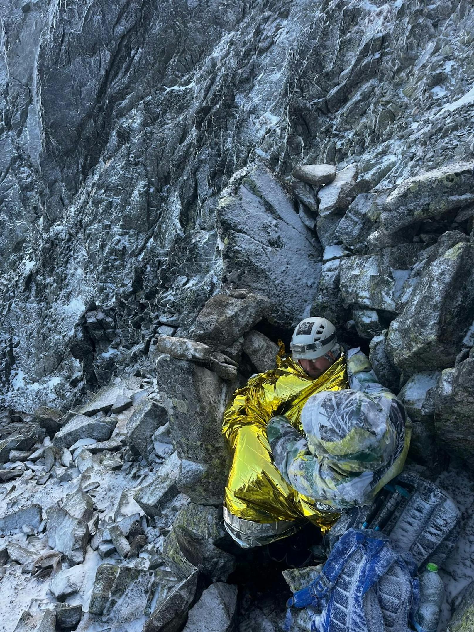 Der slowakische Bergrettungsdienst veröffentlichte nun Bilder dieser dramatischen Rettungsaktion. Auf den Fotos sieht man einen der Touristen, der in wärmender Goldfolie in einer Felsspalte sitzt, stark unterkühlt und zitternd.