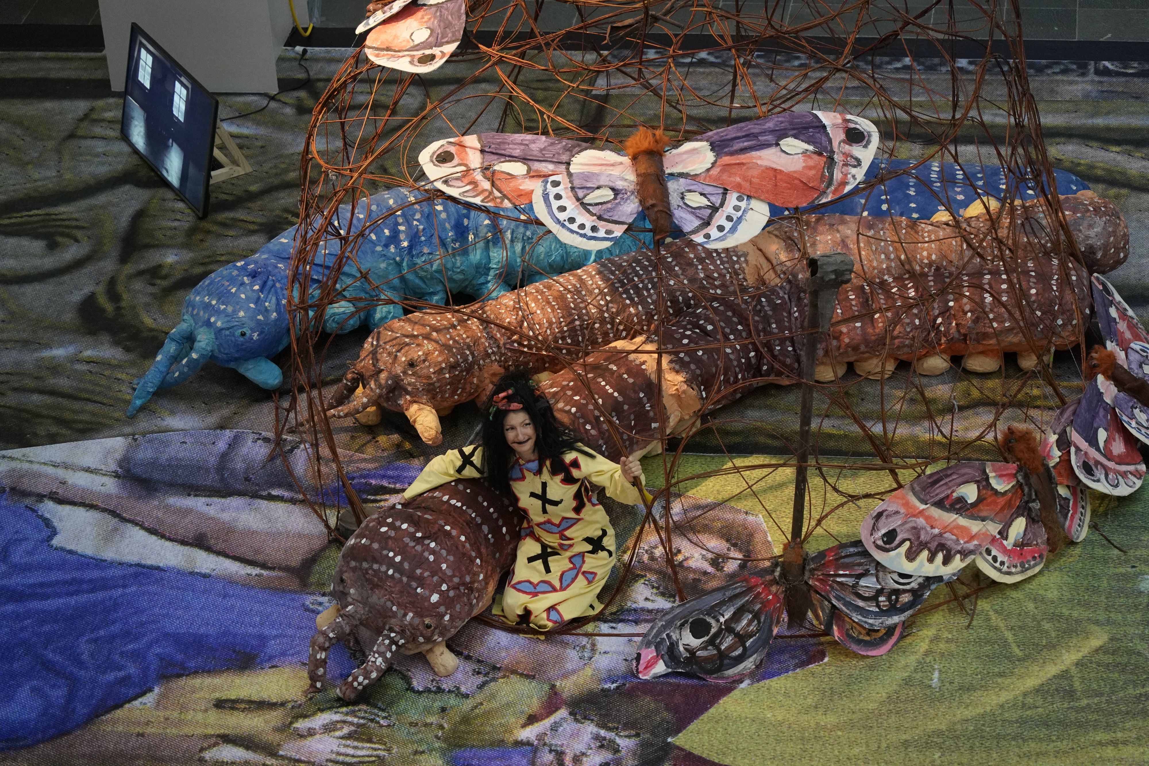 Die Künstlerin Monster sitzt in ihrer Kunst.