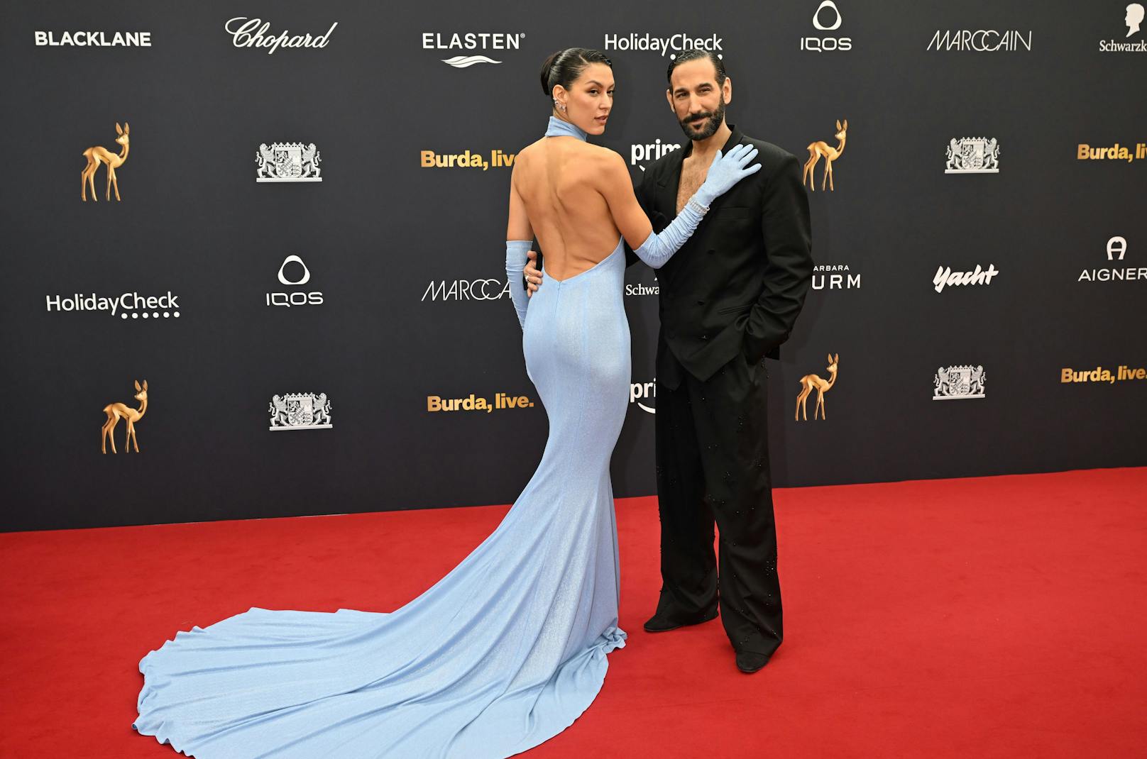 Rebecca Mir und Massimo Sinató posieren gekonnt auf dem Red Carpet der Bambi-Verleihung. Der tiefe Rückenausschnitt des hellblauen Kleides der Moderatorin kam perfekt zur Geltung.