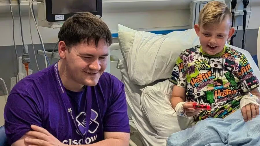Steven Mair zockt mit einem jungen Patienten in Glasgow.