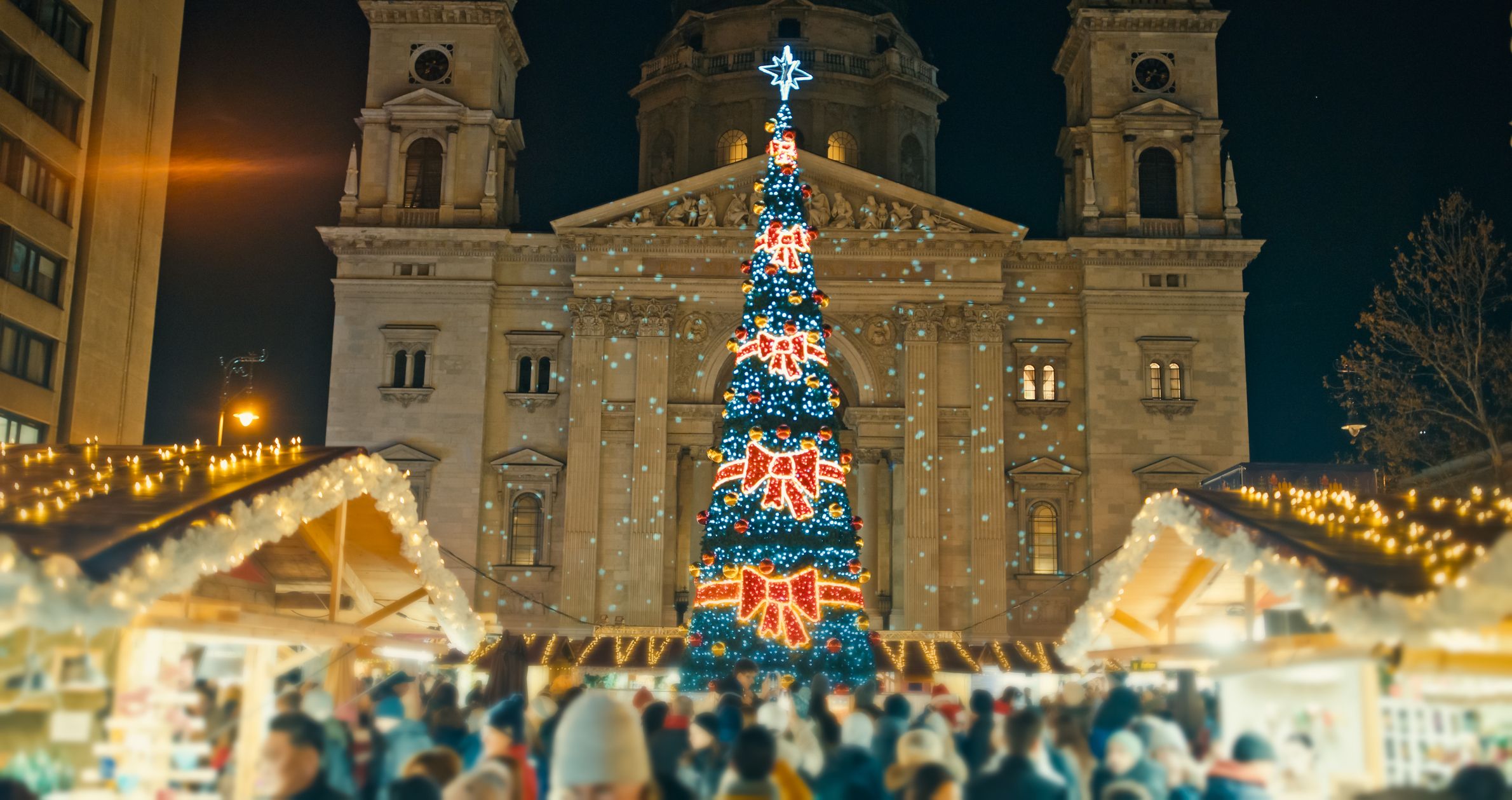 Radiant Centerpiece,an Illuminated Christmas Tree Shines Brightly at the Market Outside St Stephen's Basilica at Night in Budapest,Hungary. The Enchanting Scene Captures the Festive Spirit and Holiday Magic in the Heart of the City