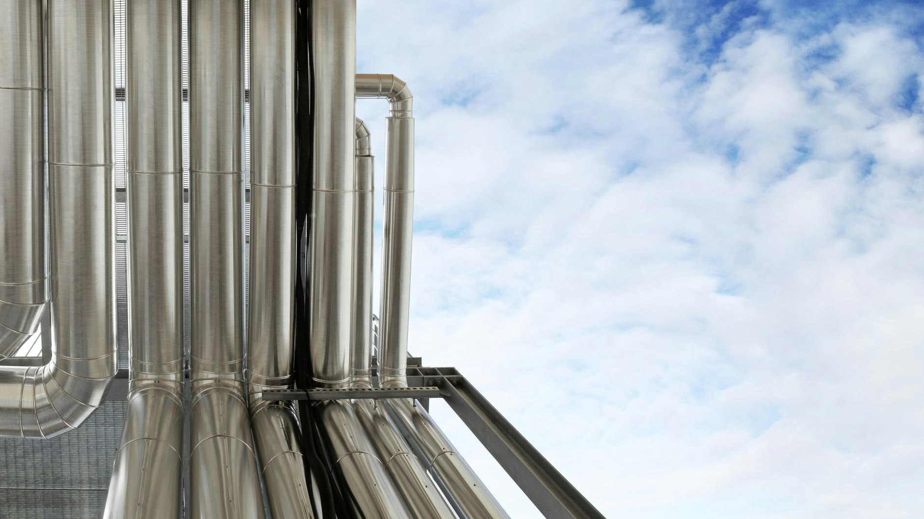 Pipes in blue sky, sustainable renewable energy, control of central heating and cooling of industrial plant air ventilation through ductwork system ducted, banner with copy space,