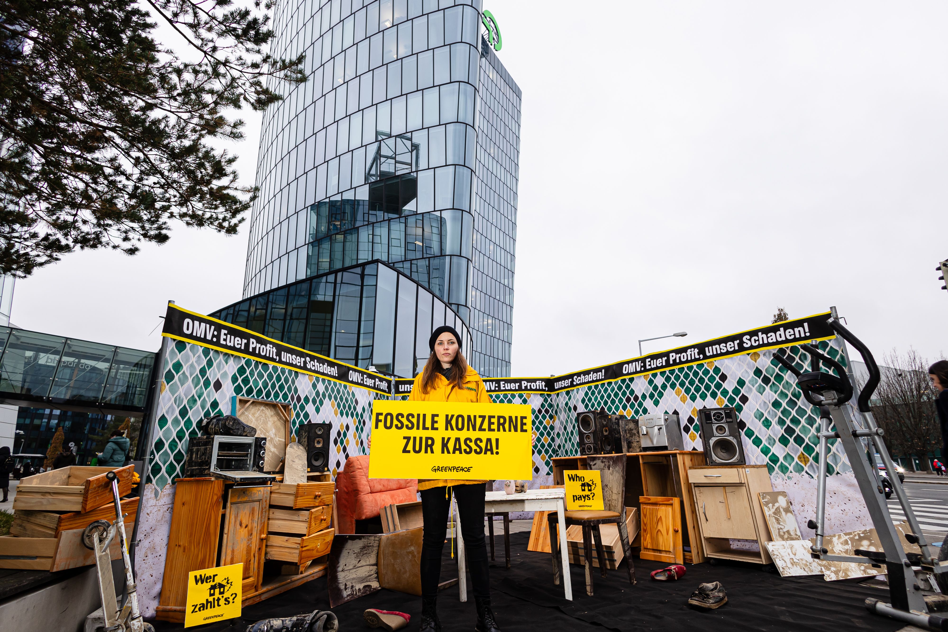 Greenpeace-Aktivisten bauten vor der OMV-Zentrale in Wien aus Hochwasser-Möbeln ein Wohnzimmer nach.