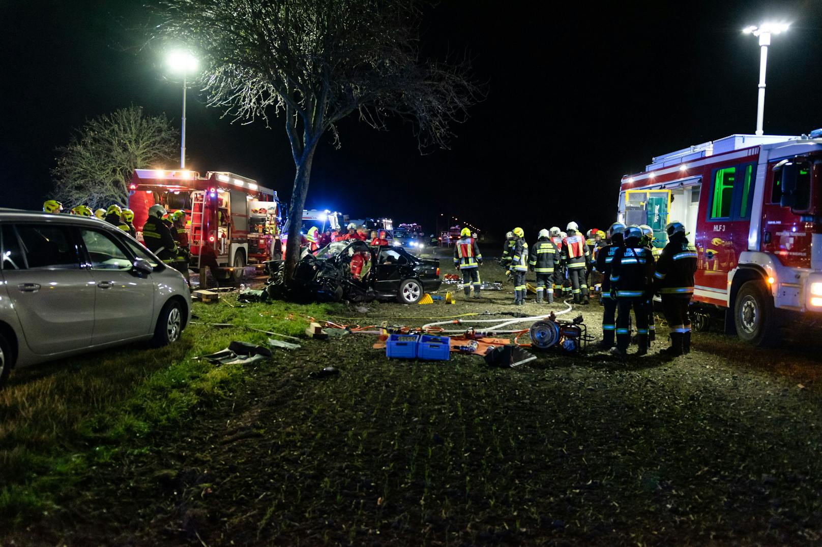 Der völlig demolierte 3er-BMW; Einsatzkräfte vor Ort.