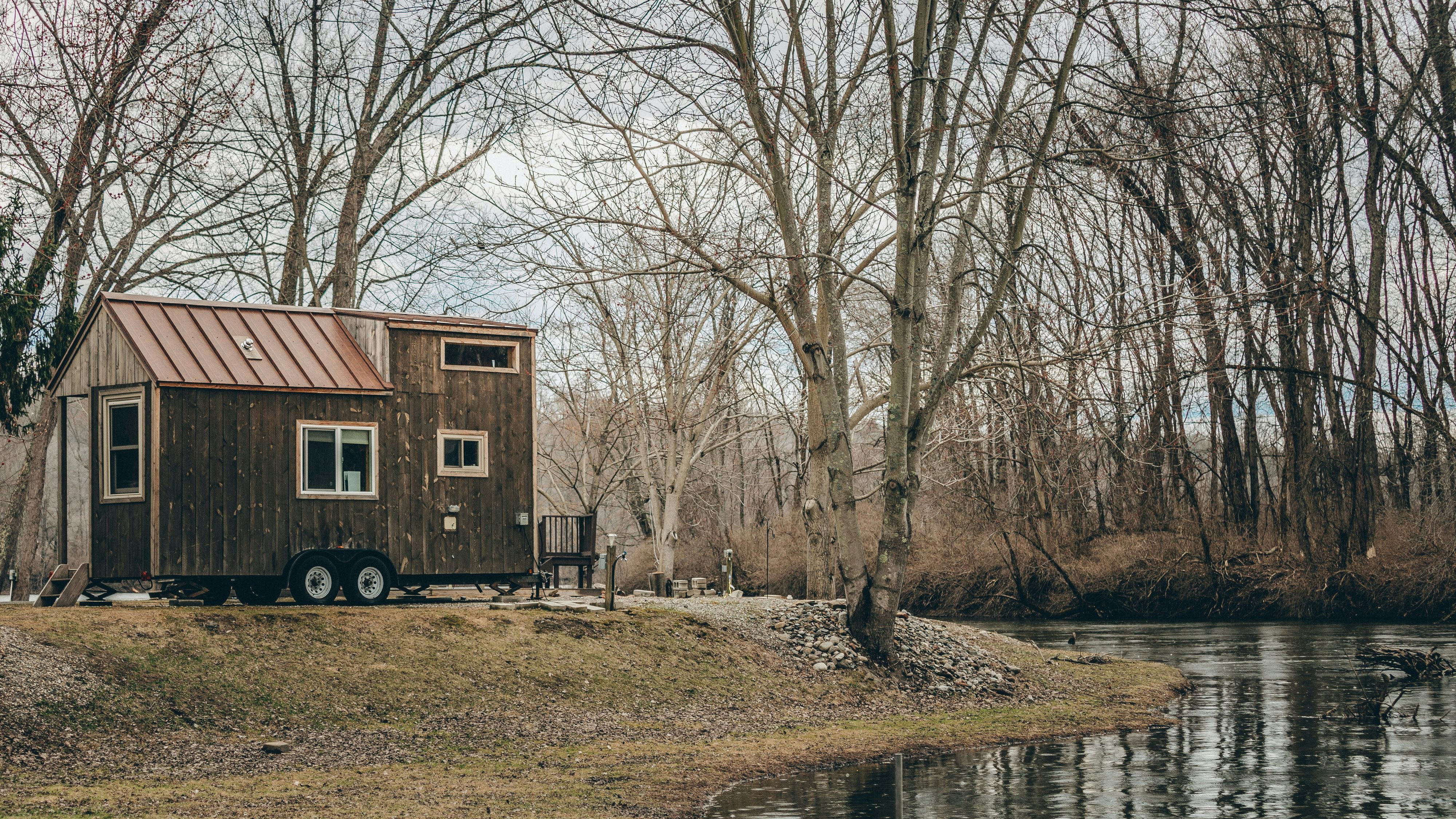 A tiny home and tree reflection in a pond in New England.