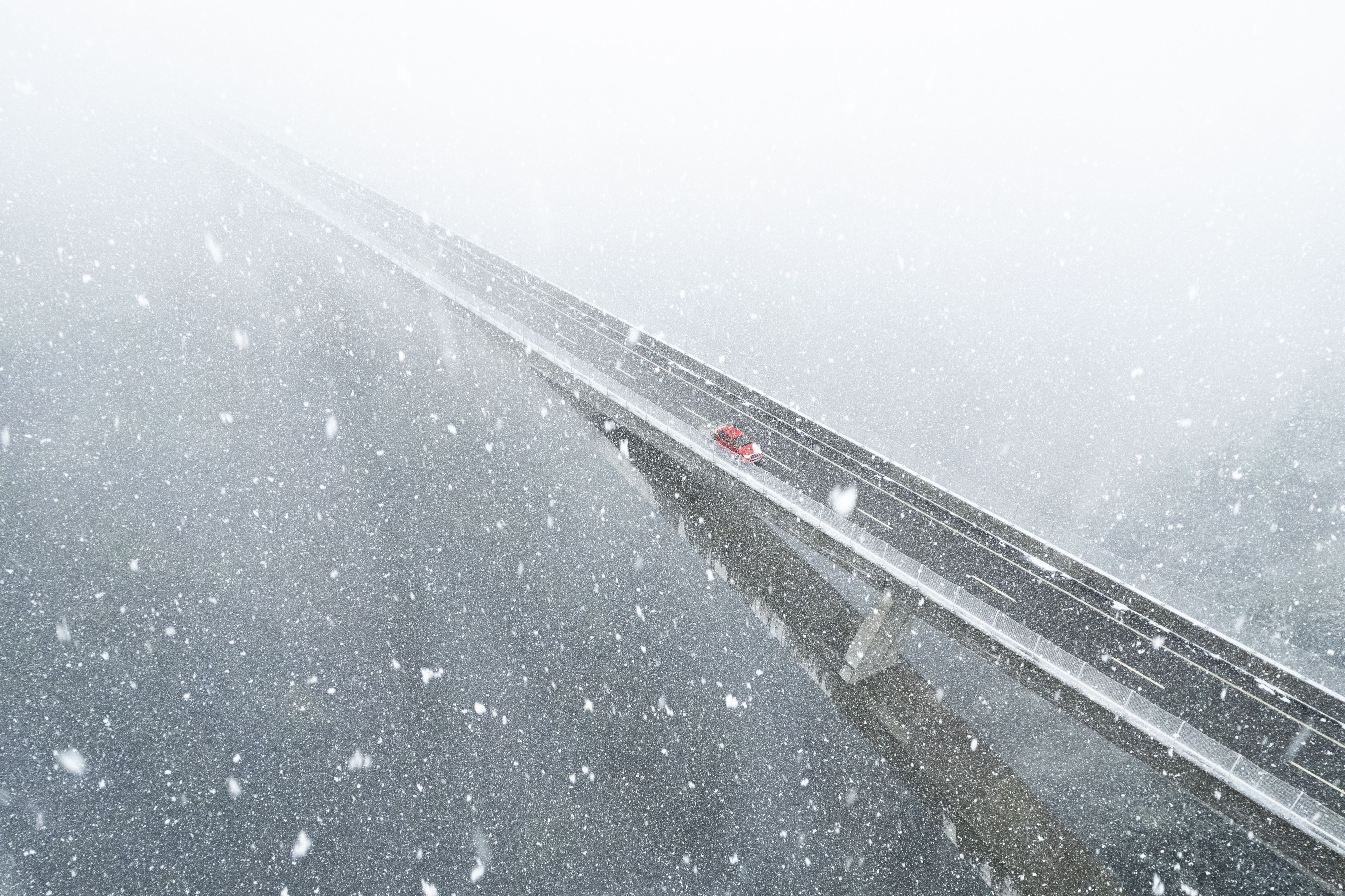 Ein Auto auf der Taminabrücke, Pfäfers, während ungewöhnlich starkem Schneefall.