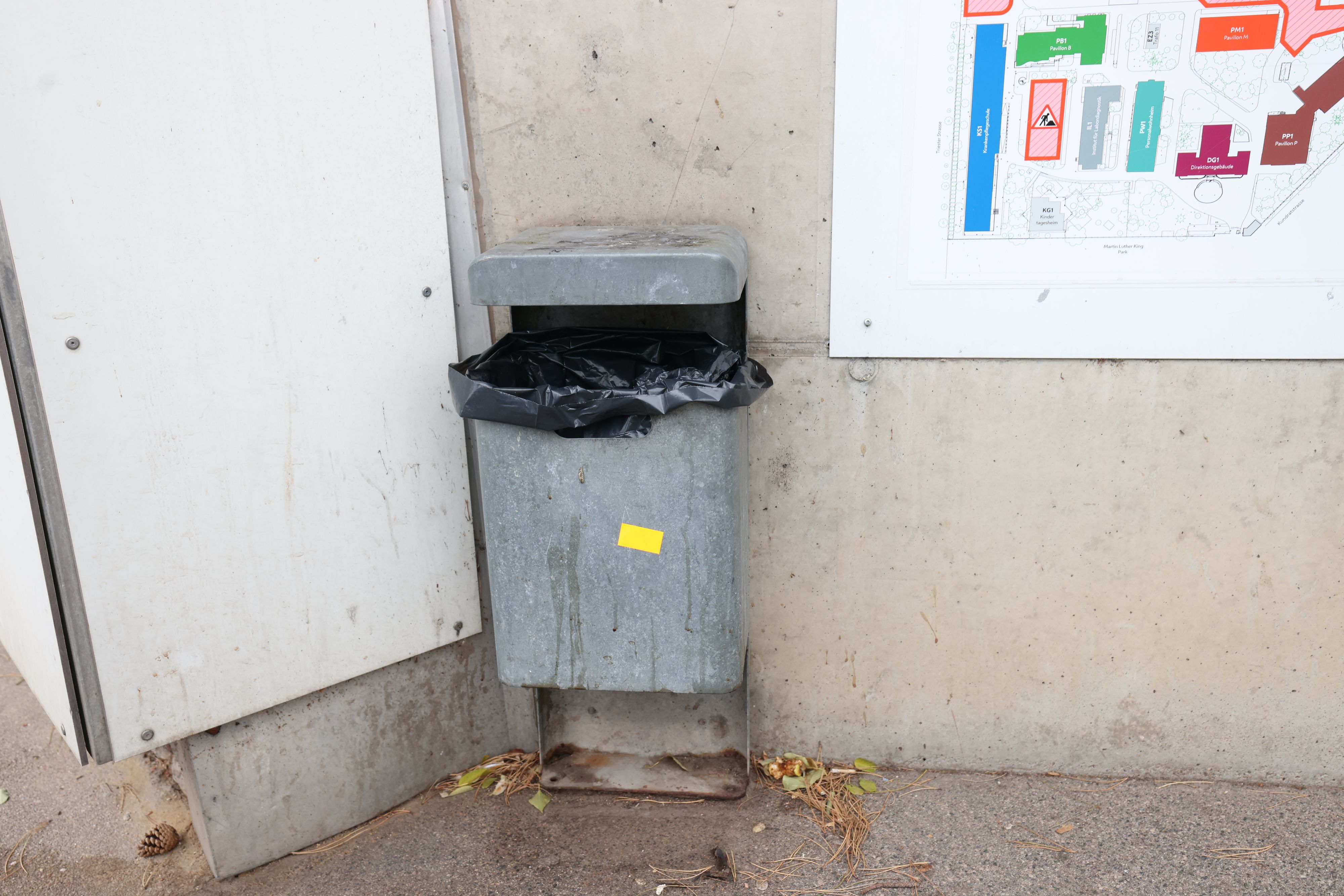 Die Frau warf zwei Zettel in einen öffentlichen Mistkübel.