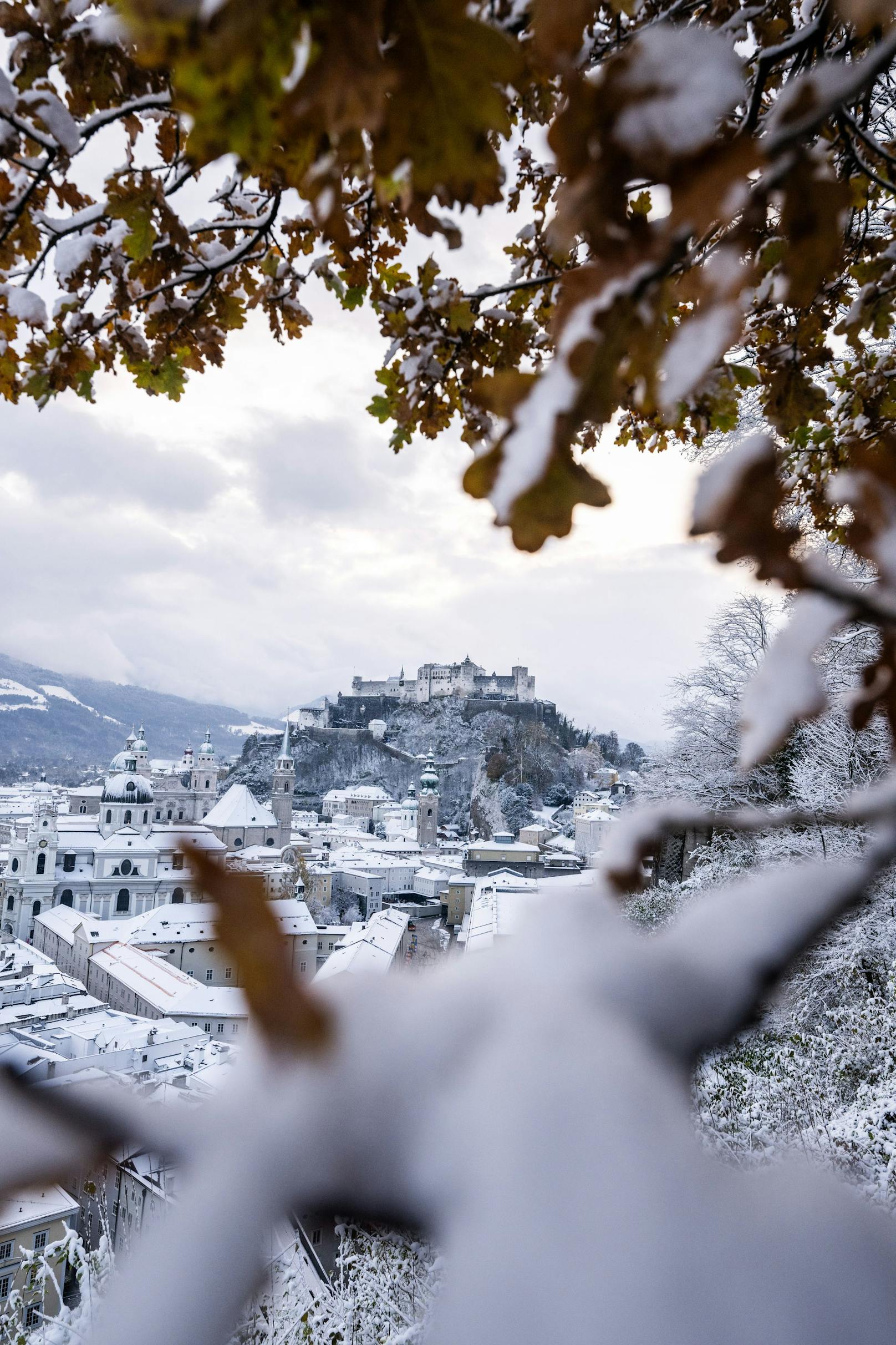 Ausblick auf die frisch verschneite Stadt Salzburg und die Festung Hohensalzburg.