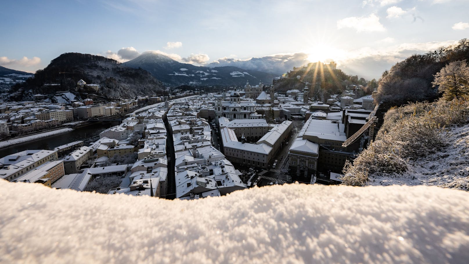 Ausblick auf die frisch verschneite Stadt Salzburg und die Festung Hohensalzburg.