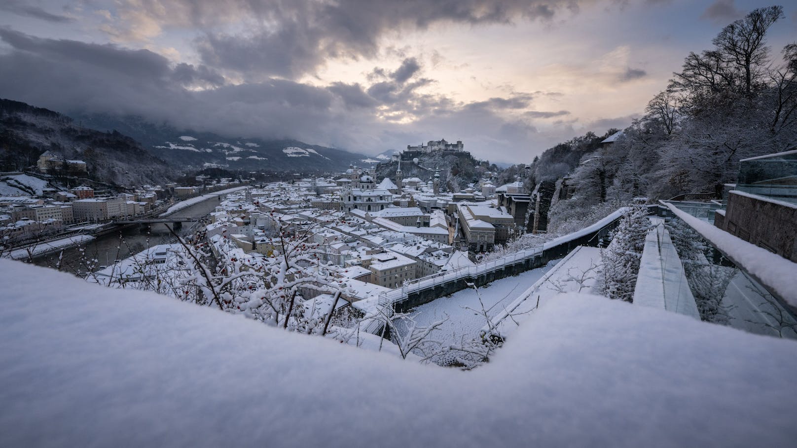 Ausblick auf die frisch verschneite Stadt Salzburg und die Festung Hohensalzburg.