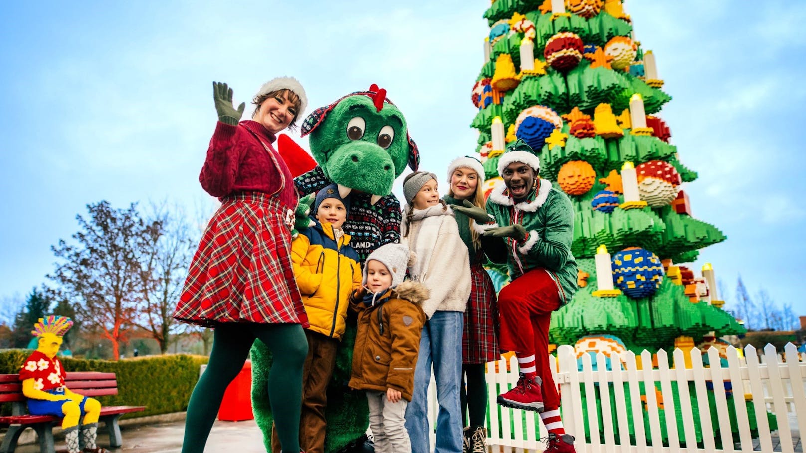 Parkdrache Olli und die Winterelfen vor dem großen LEGO DUPLO Weihnachtsbaum.