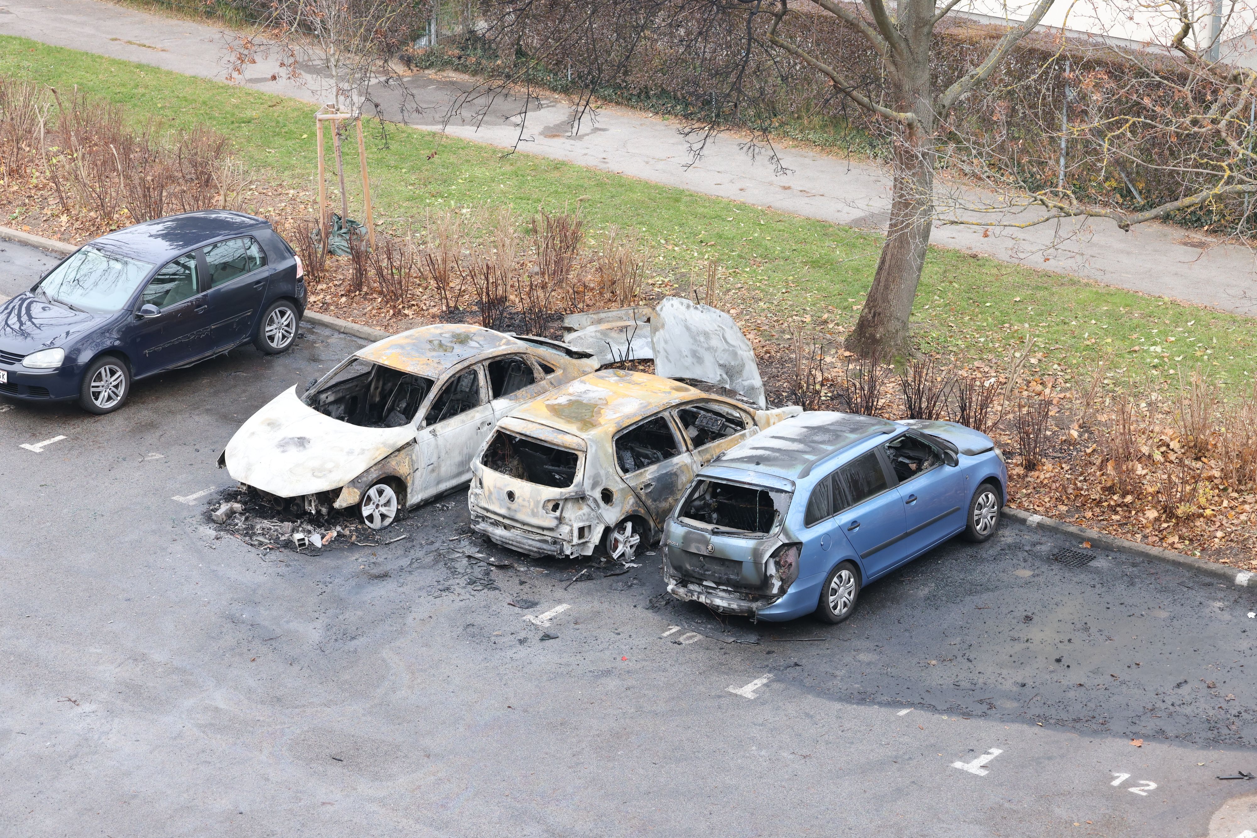 Drei vollständig ausgebrannte Autos auf dem Parkplatz in der Kainachgasse – die Spuren der Flammen sind unübersehbar.