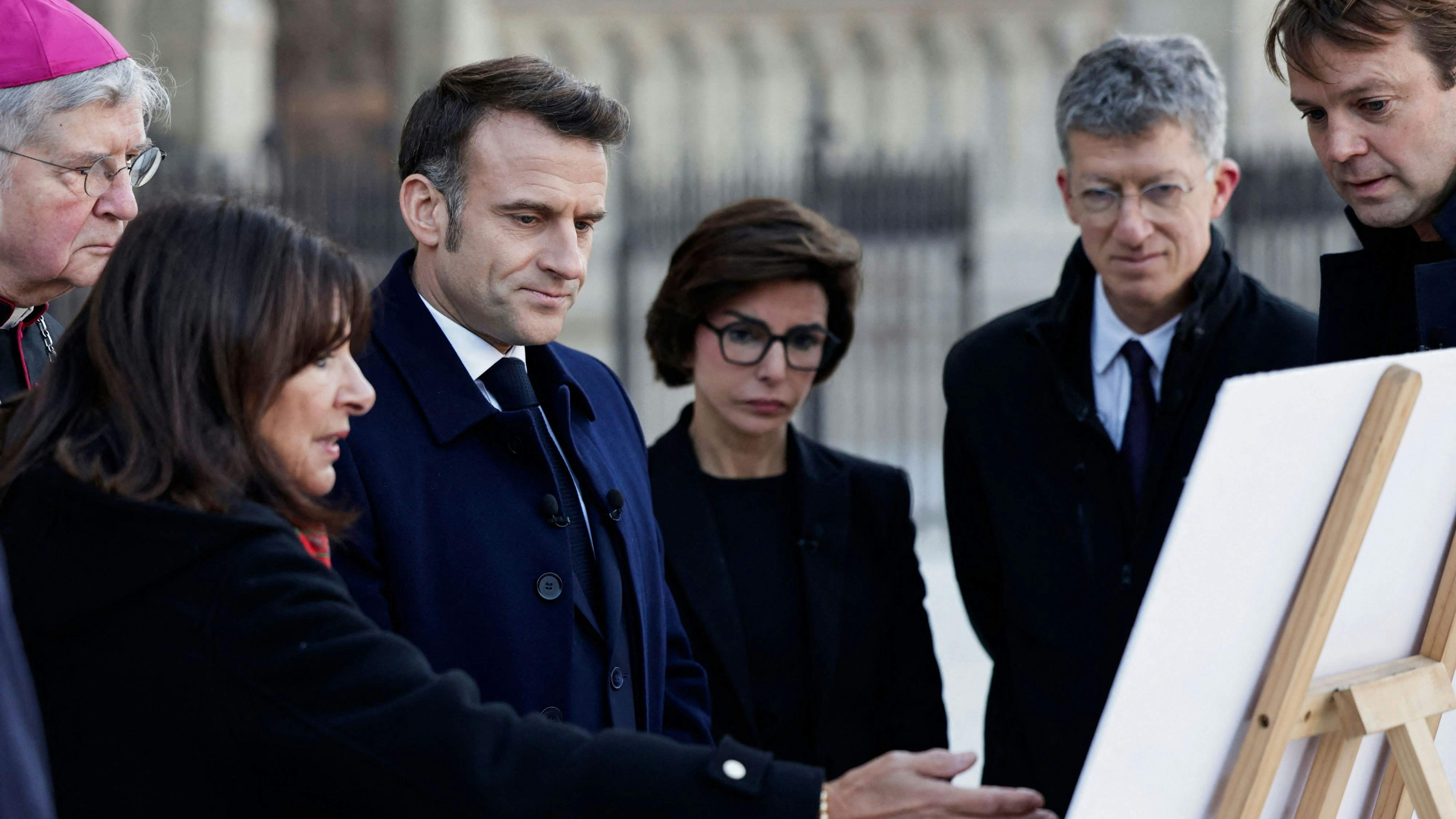 Präsident Emmanuel Macron (3. v. l.) mit Bürgermeisterin Anne Hidalgo (2. v. l.) Erzbischof Laurent Ulrich (l.) und Kulturministerin Rachida Dati