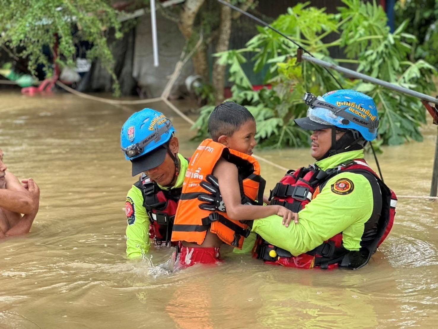 Männer retten ein Kind in der Provinz Yala in Süd-Thailand. Bei Überschwemmungen sind bereits acht Menschen gestorben.