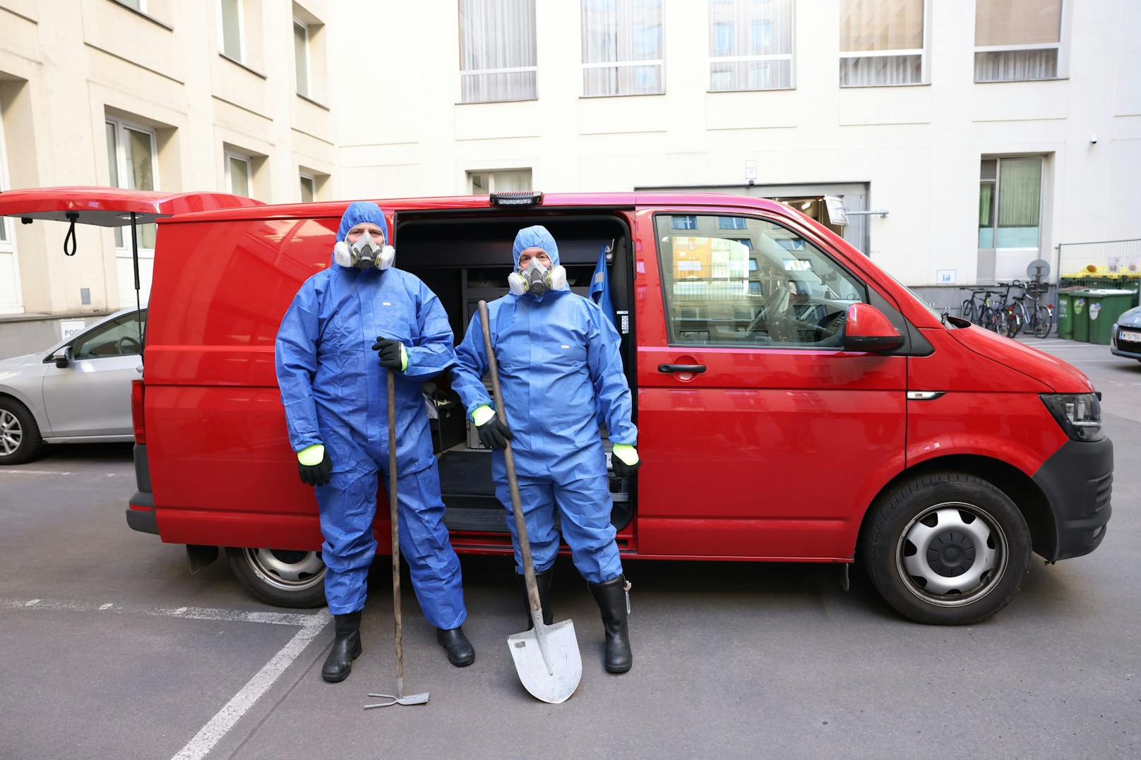 Bereit für den Einsatz: Zwei Ermittler der Brandgruppe in voller Schutzausrüstung mit Atemmasken vor ihrem Einsatzfahrzeug.